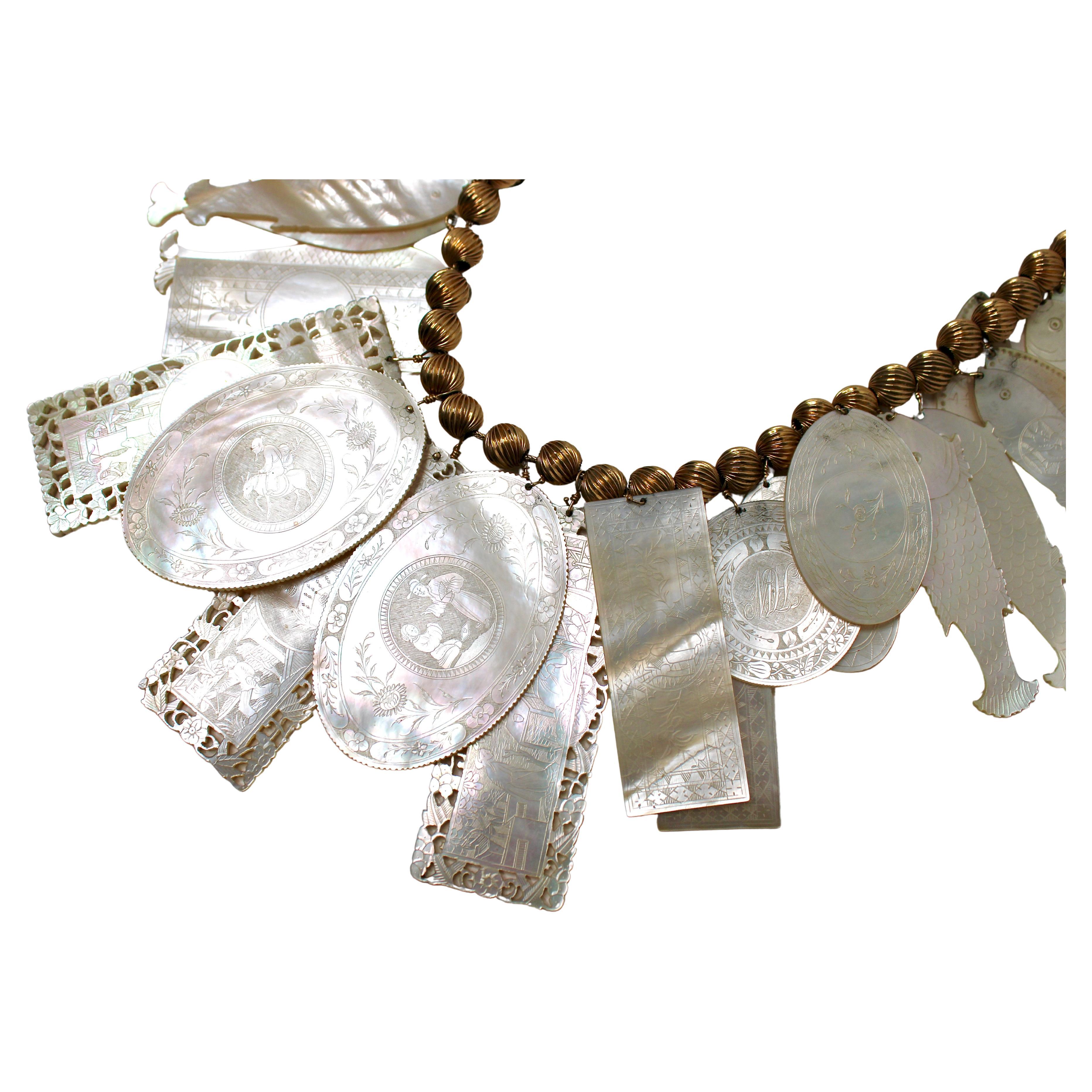 Questa squisita collana di Madreperla con conchiglia incisa in oro 14k risale agli anni '60, ed è un pezzo vintage raro e unico nel suo genere. La collana presenta numerose conchiglie finemente incise, ognuna delle quali mostra intricati disegni di