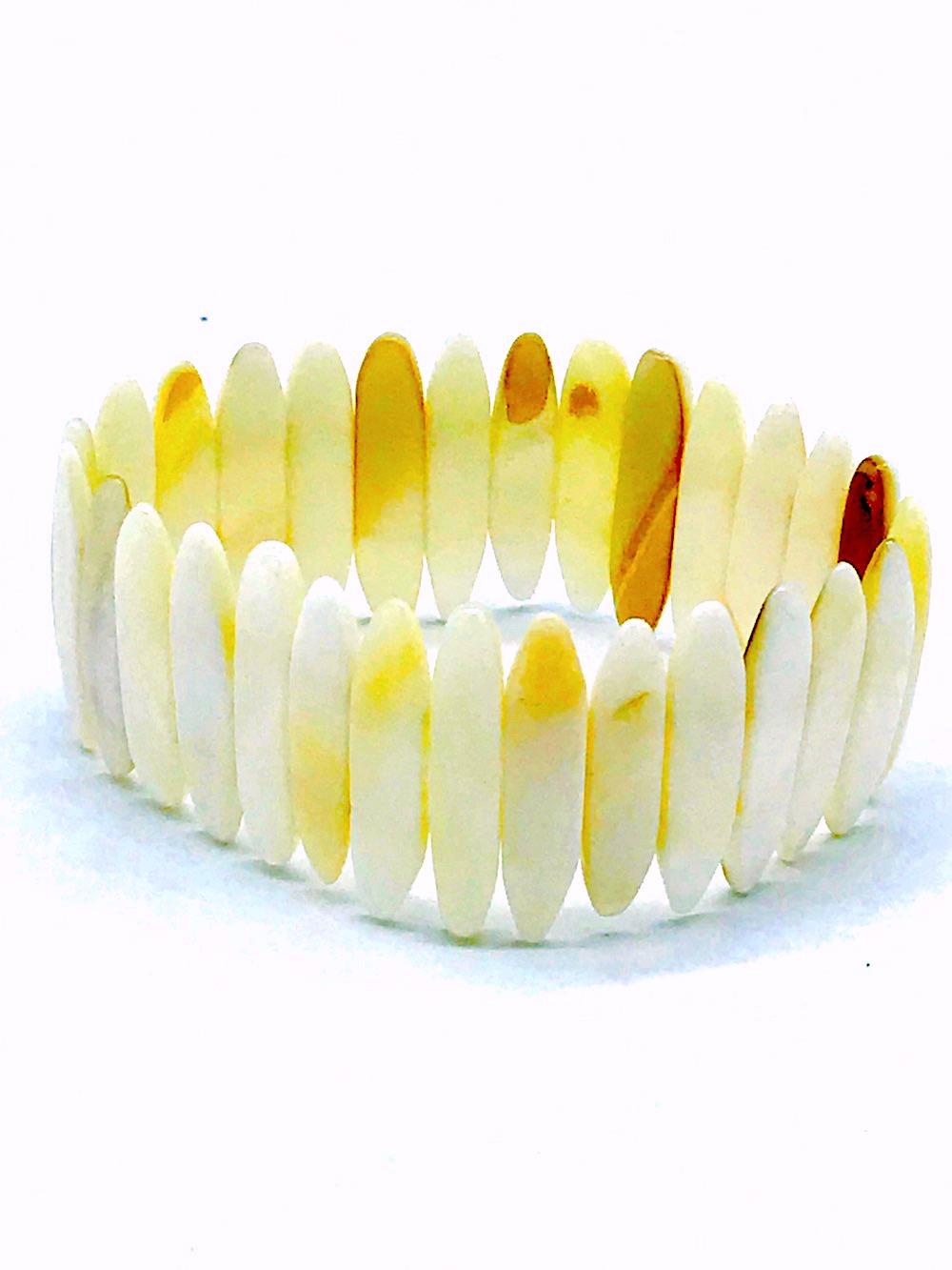 Mother of Pearl, Expandable Hand Cut BraceletLuminesce, white colored measuring 1 inch long an 6.5 mm wide. The mother of pearl shells  are set in a double row of elastic to expand this bracelet. GIA Gemologist inspected and evaluated