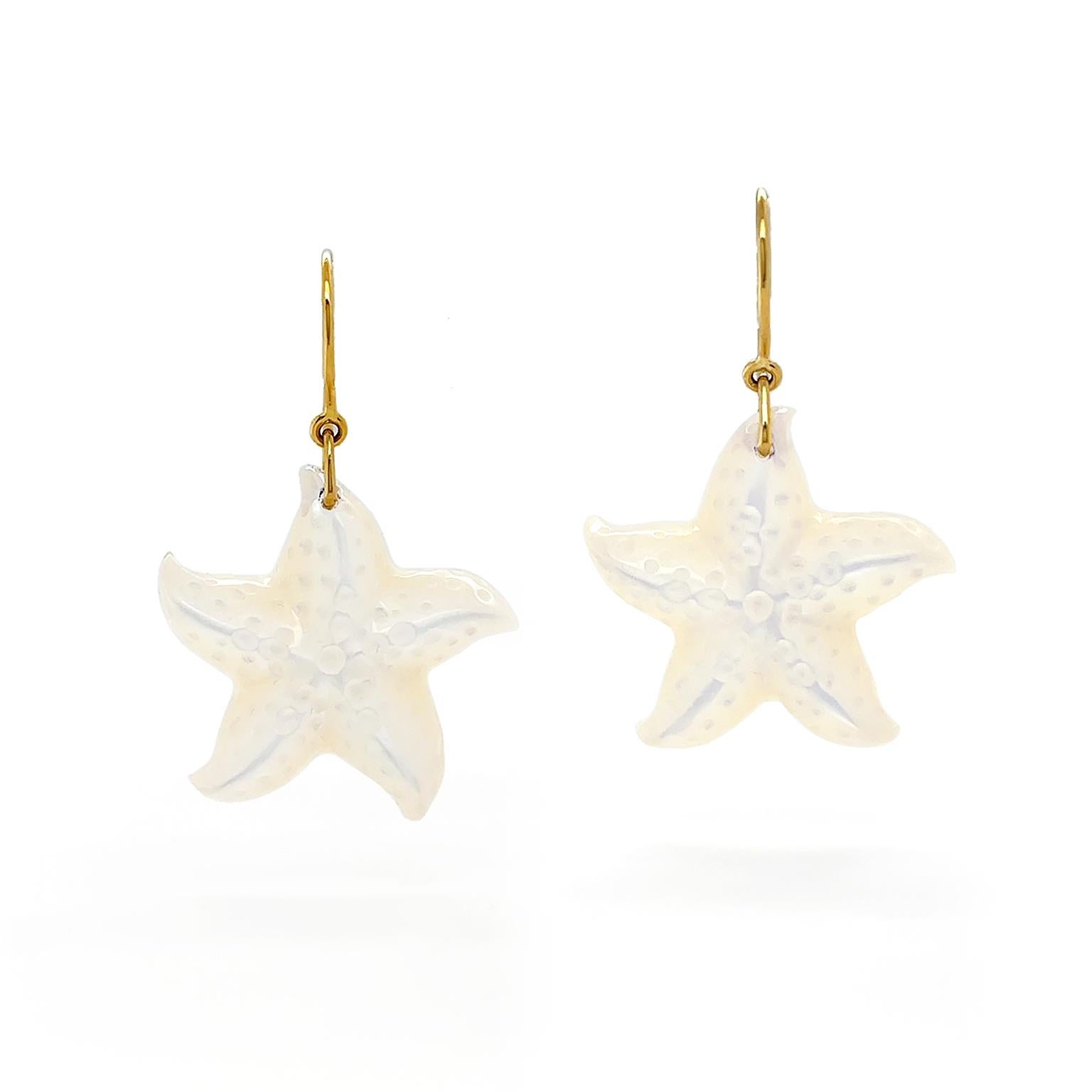 The shimmer of the mother of pearl gives an ethereal essence as it illustrates starfish. Artisanship in the design includes softly curved arms and texture throughout. The total weight of the mother of pearl is 2 carats. 18k yellow gold French hooks