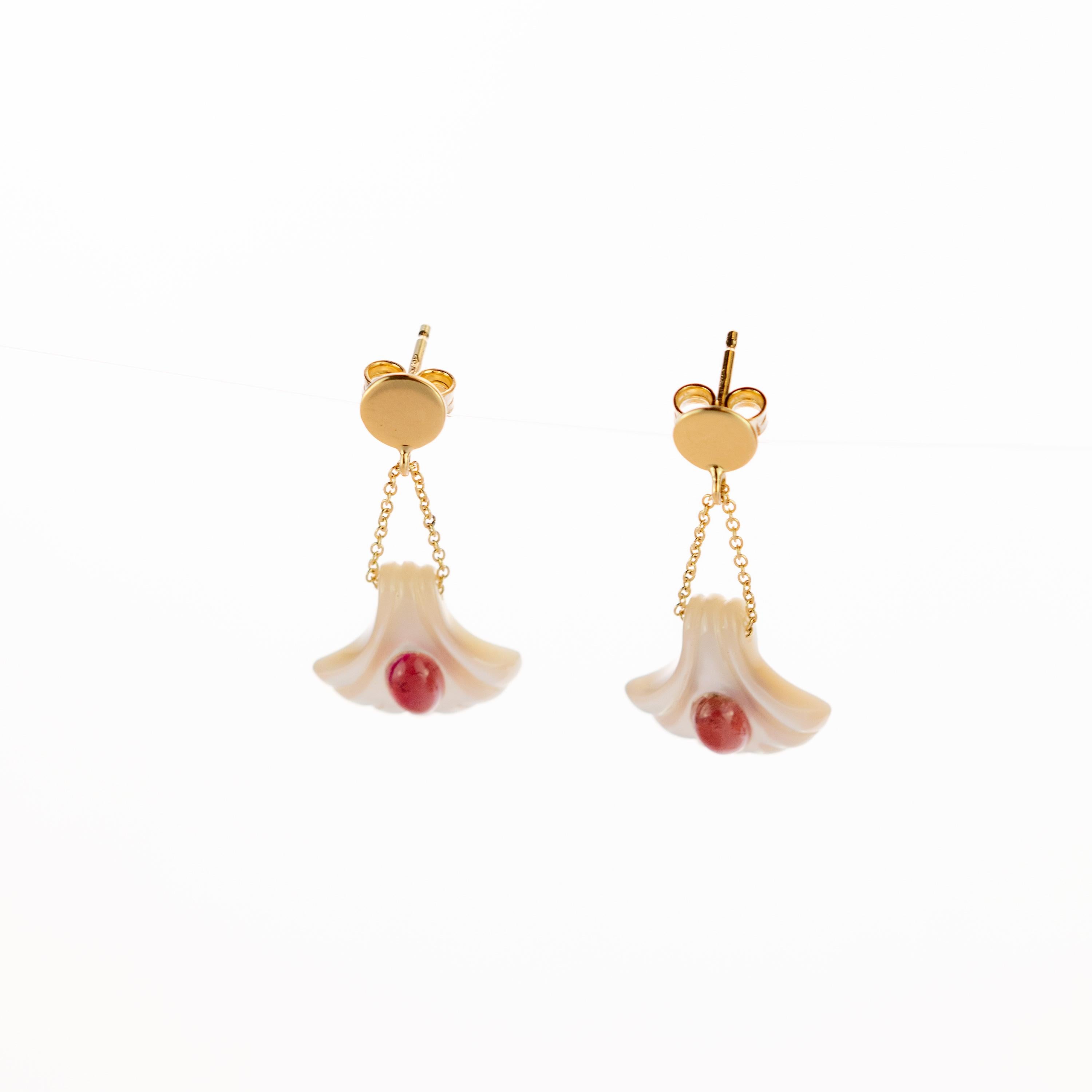 Glamorous earrings with two delicate 18 karat yellow gold chains that start in a gold circle and finish in a beautifully carved mother of pearl shell. To enhance the jewellery an oval natural pink tourmaline is gently added decorating the center of