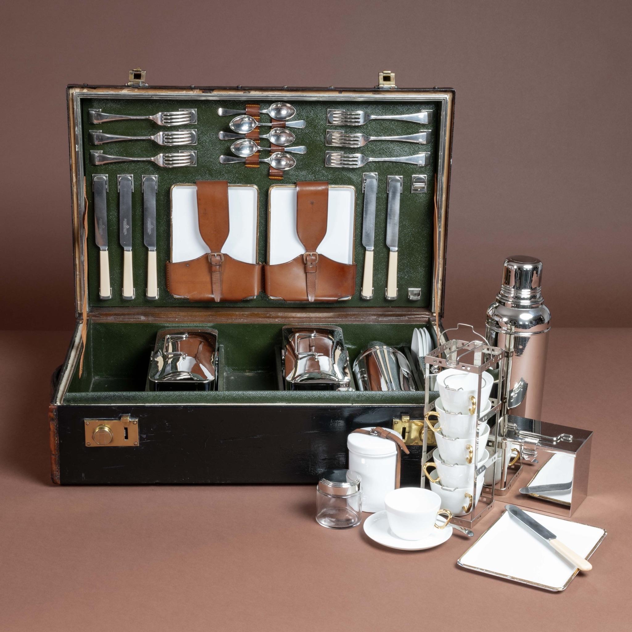 Impressive six person motoring picnic case; circa 1910. The collection comprises six enamelled tin plates, six ceramic cups with matching saucers and enough cutlery for six individuals.

Additionally, it contains two enamelled tin food containers
