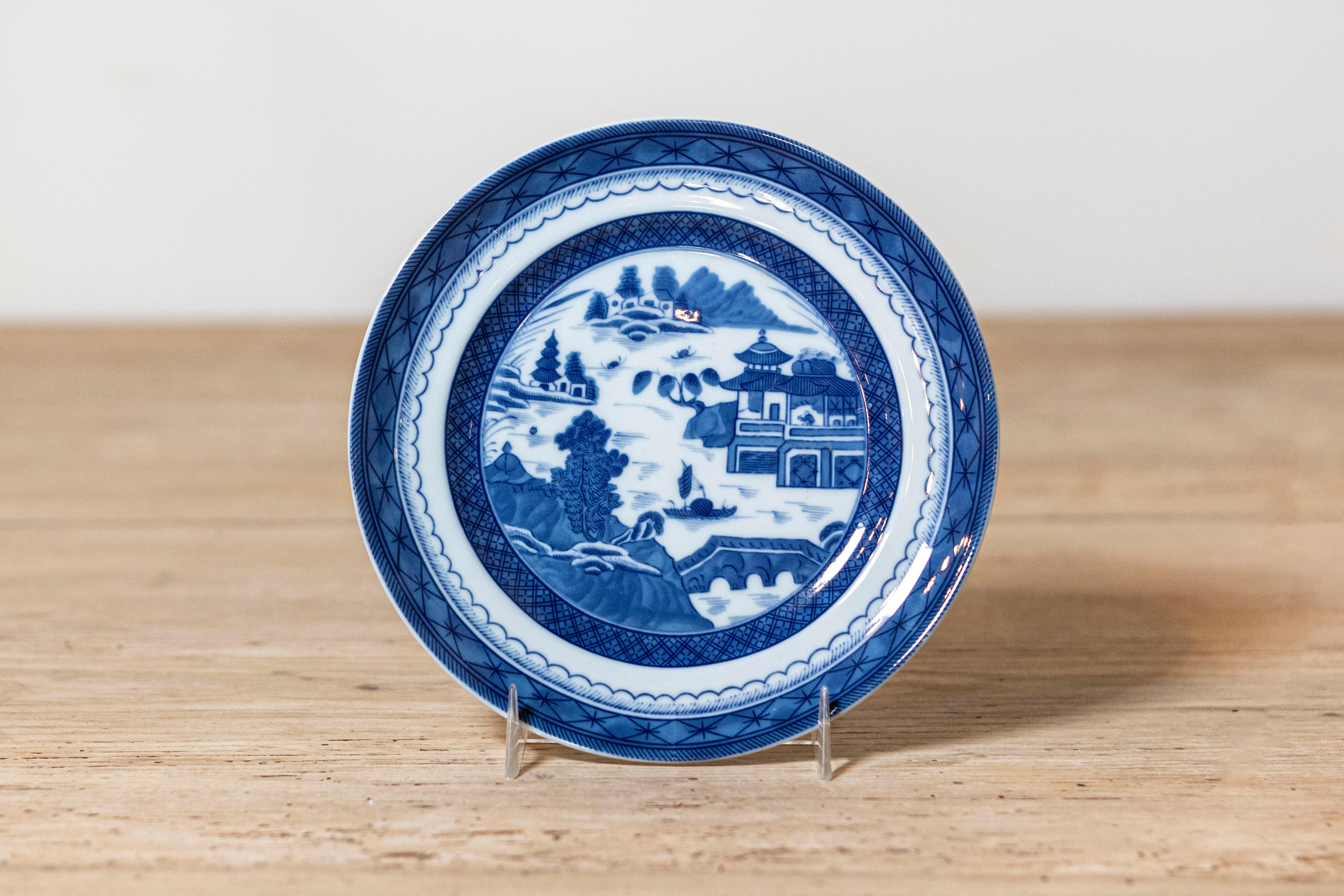 A Mottahedeh Blue Canton blue and white porcelain salad plate from the 20th century with pagoda and geometric accents. Created in Portugal by Mottahedeh under license of the Historic Charleston Foundation to reproduce the design of the original