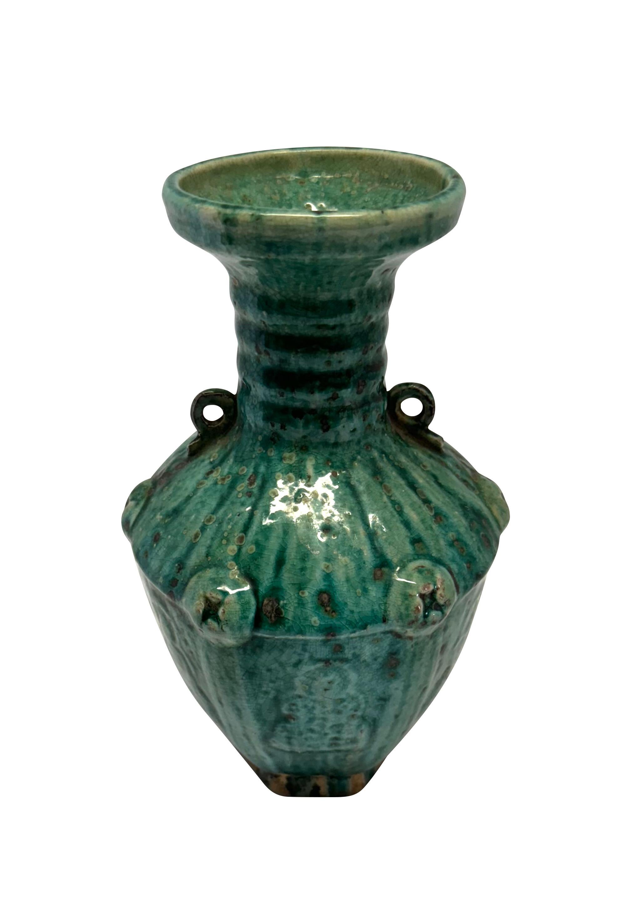 Vaso cinese contemporaneo color smeraldo screziato con smalto crepla.
Design a coste orizzontali sul collo del vaso.
Due piccole maniglie.
Un motivo verticale in rilievo definisce le sezioni del vaso.
Design complessivo con texture a rilievo.
Sono