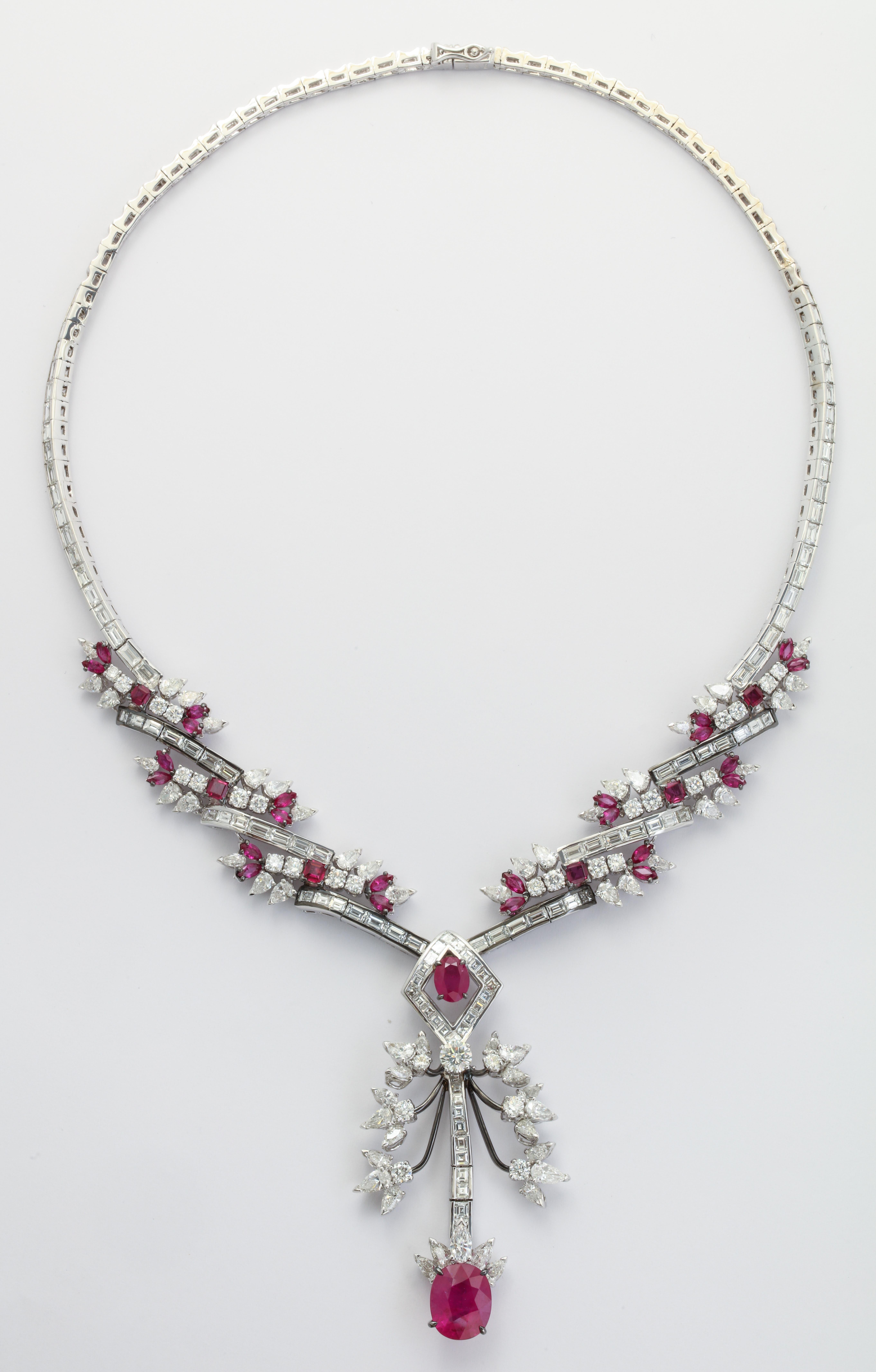 The highly important complete set features a necklace with detachable pendant, a flexible bracelet, hanging earrings and a ring.  Each of the pieces is set with numerous rubies and diamonds and features at least one larger, central, ruby.  The suite