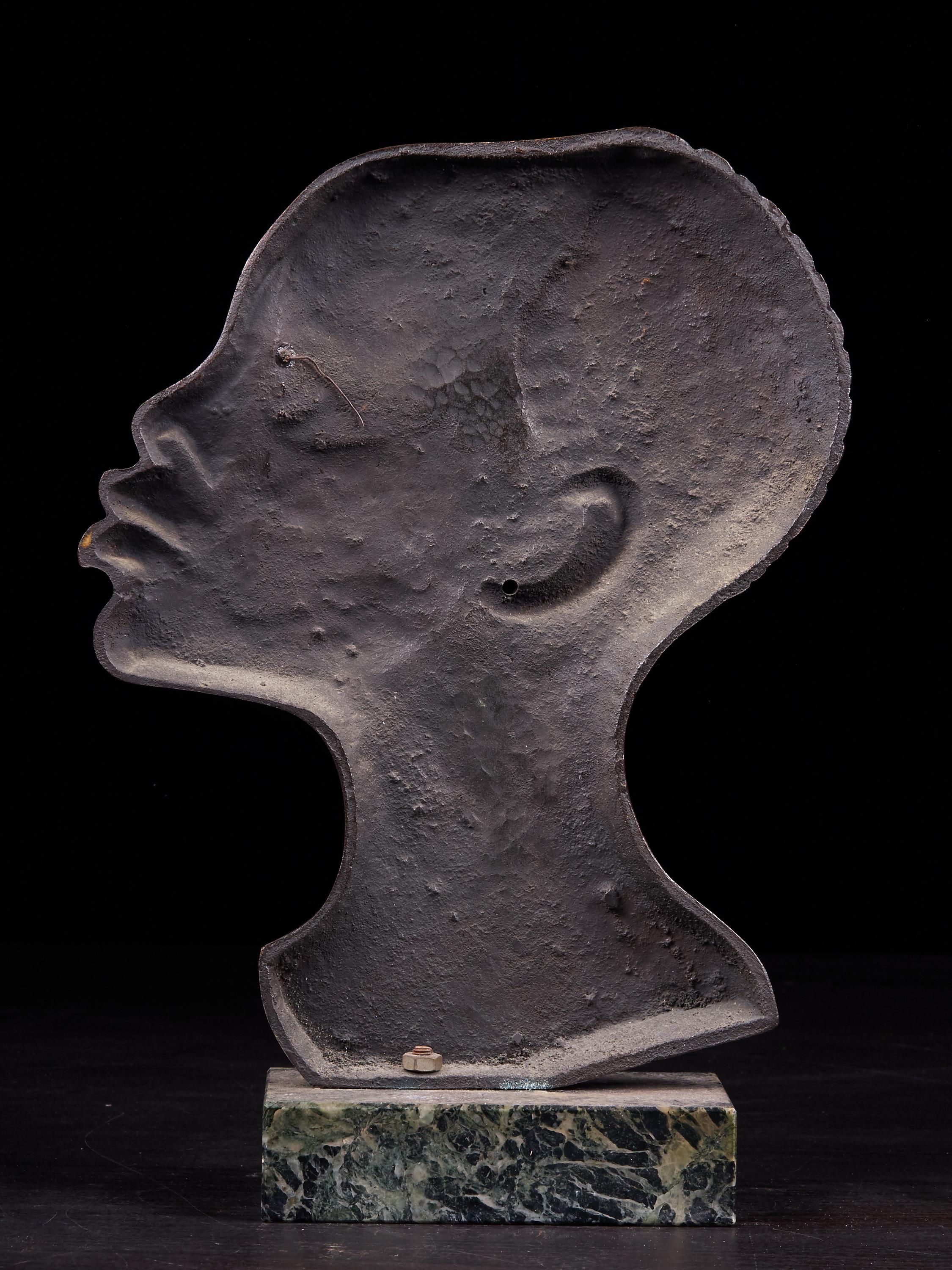 Striking moulded matte copper alloy profile of an African figure's head with relief hair and shiny lips. This untagged item is set on a base of blue green turquoise stone.