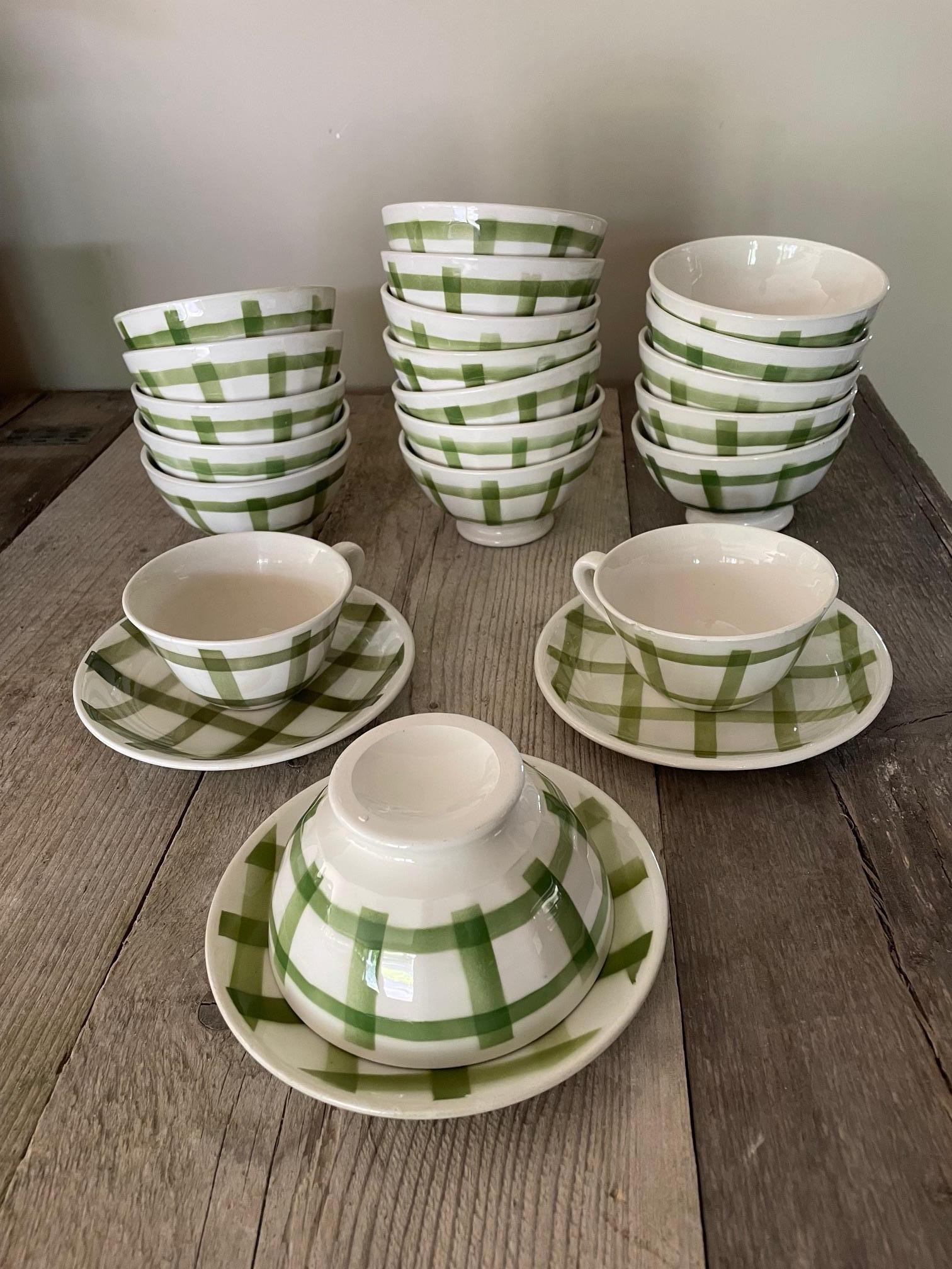 Moulins des Loups green gingham earthenware bowl set. The set comprises 15 bowls, one of which is embossed, as well as two cups 
The cups are quite damaged.
It has a pretty green Vichy decoration.