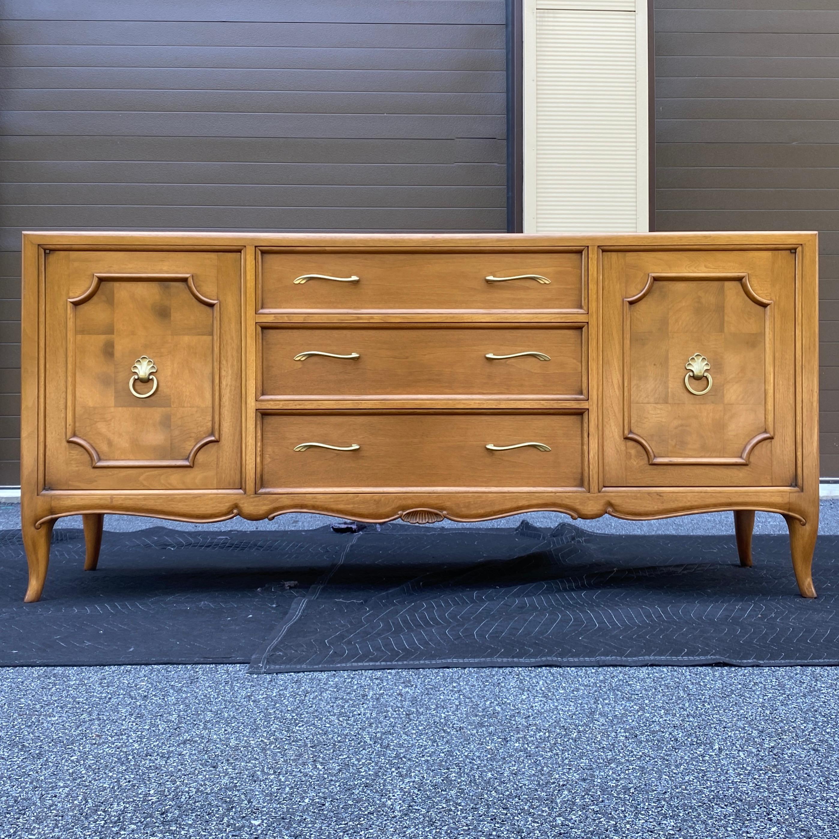 High end walnut credenza by Mount Airy Furniture for John Stuart featuring patchwork walnut burl door panels and unique large brass hardware. Functional and versatile storage configuration of three large center drawers with cabinets on either end