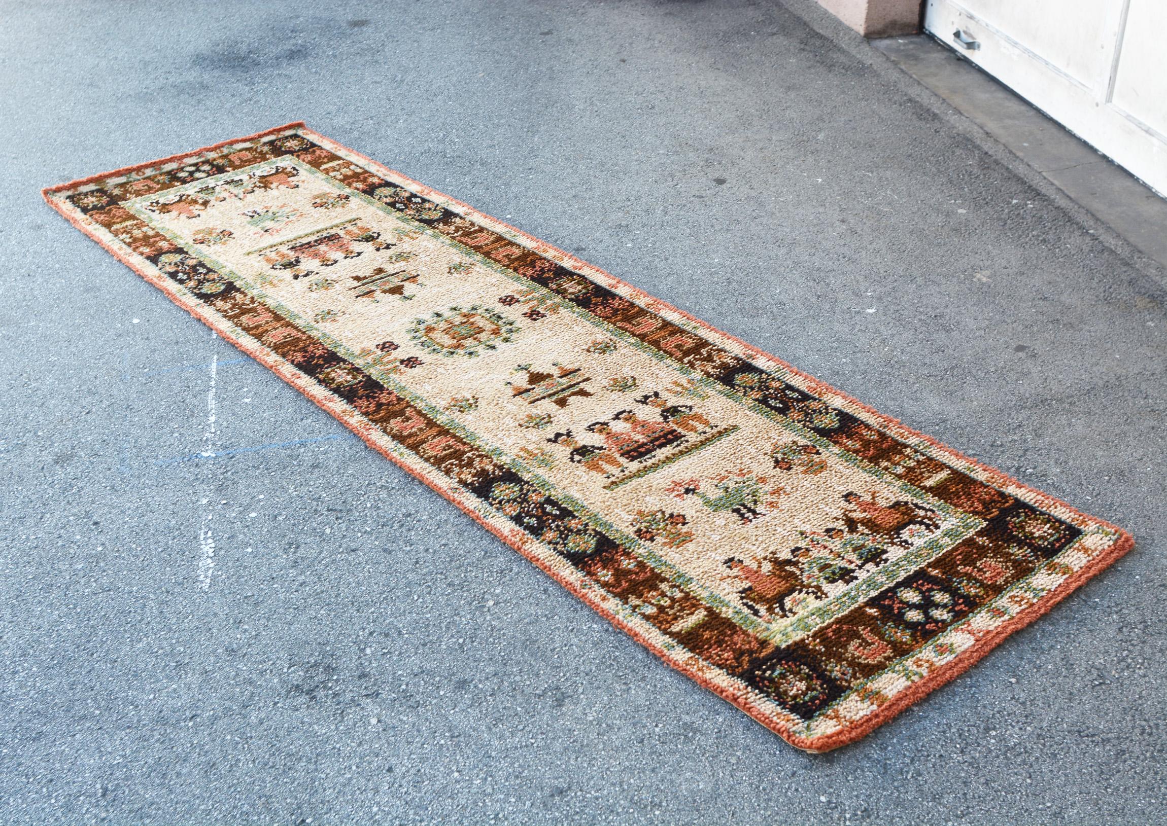 Nine foot long 100% wool runner by Ege Axminster. This is part of the Ege Country series and titled Mountain Life. This whimsical rug depicts elements of traditional life in Denmark's mountains. The pile is a half inch thick. There are no stains or
