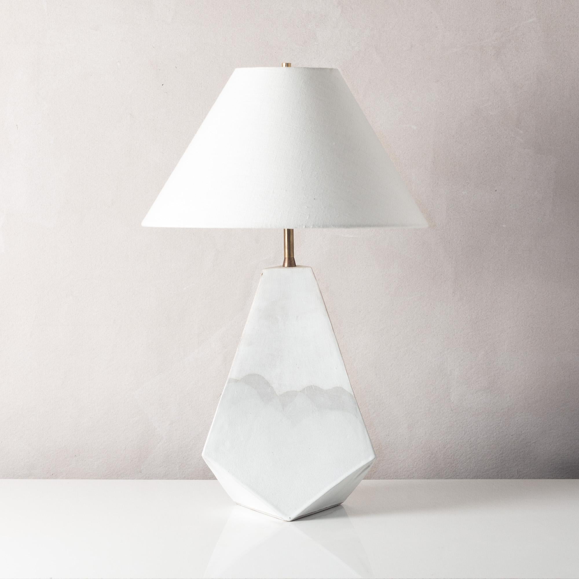 This bold geometric ceramic lamp is made from a rich red-brown clay, formed into a dramatic pyramid shape, and featuring an organic matte finish accented by hand-poured satin glaze. Each piece is individually handmade and entirely