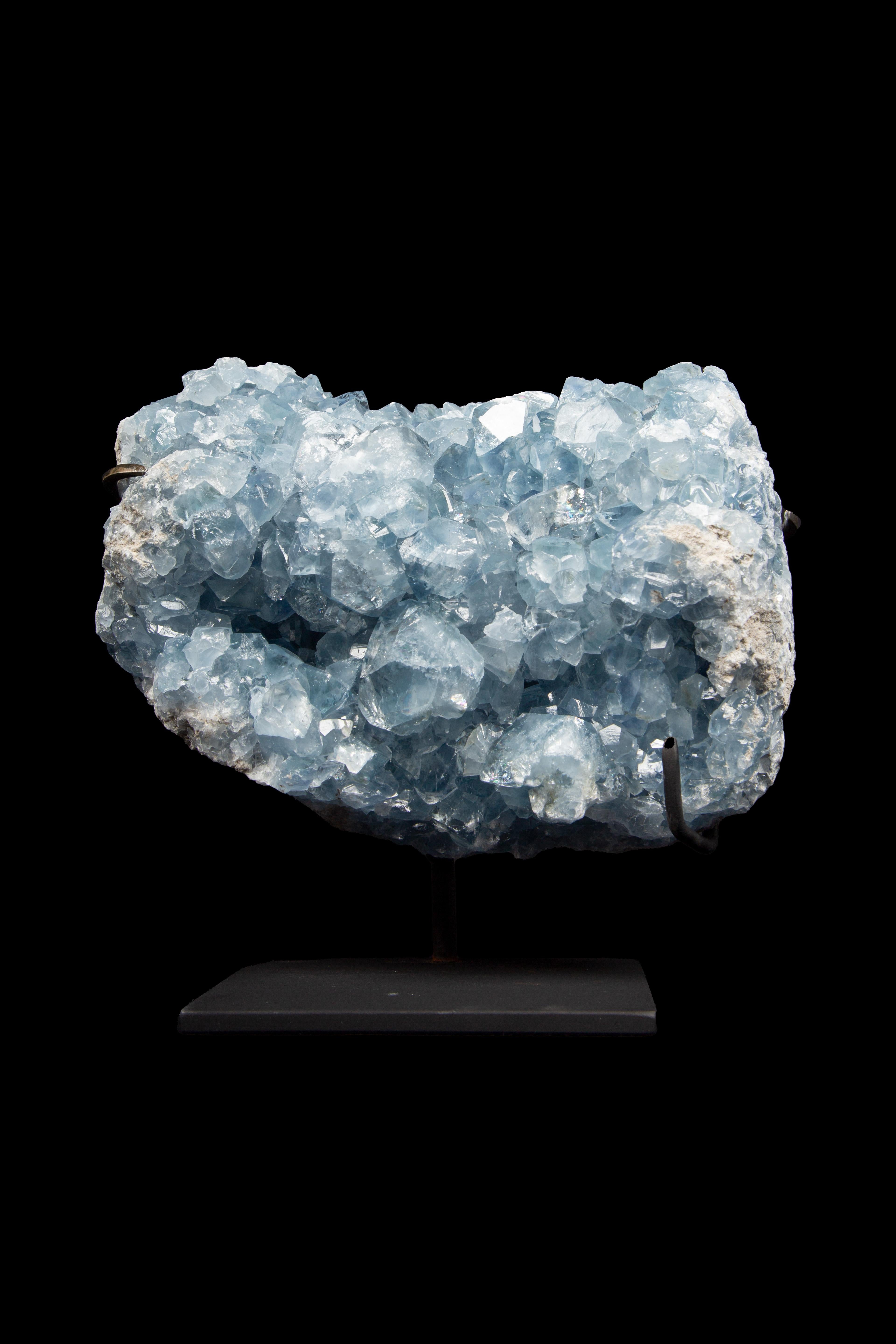  Blue Calcite specimen elegantly showcased on a meticulously crafted custom-painted metal stand. While Calcites are distributed across every continent, the exquisite Blue Calcite is a rarity, gracing only a select few locations on our planet. Though