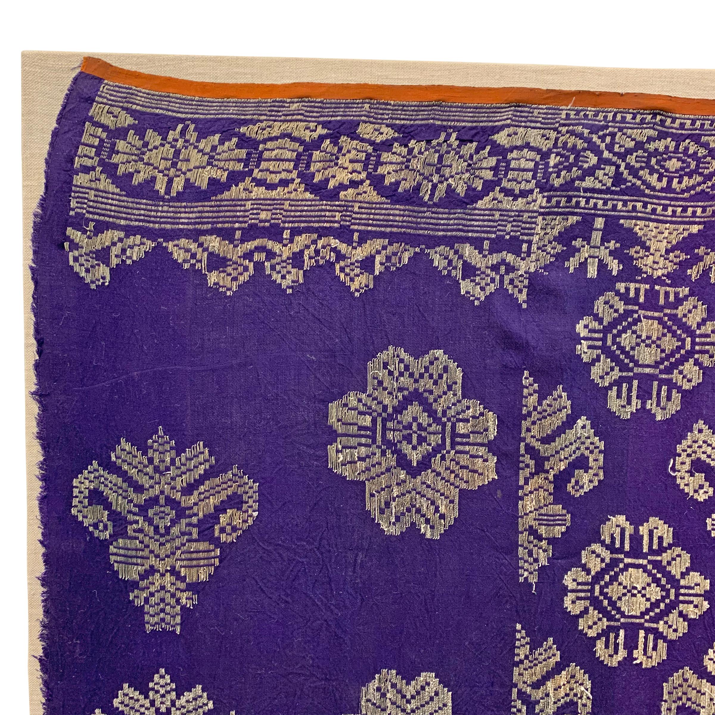 A fantastic brilliant violet early 20th century Indonesian textile with metallic silver thread embroidery woven with a stylized floral pattern and mounted on a custom linen wrapped board. It's likely that this panel was originally meant to be used