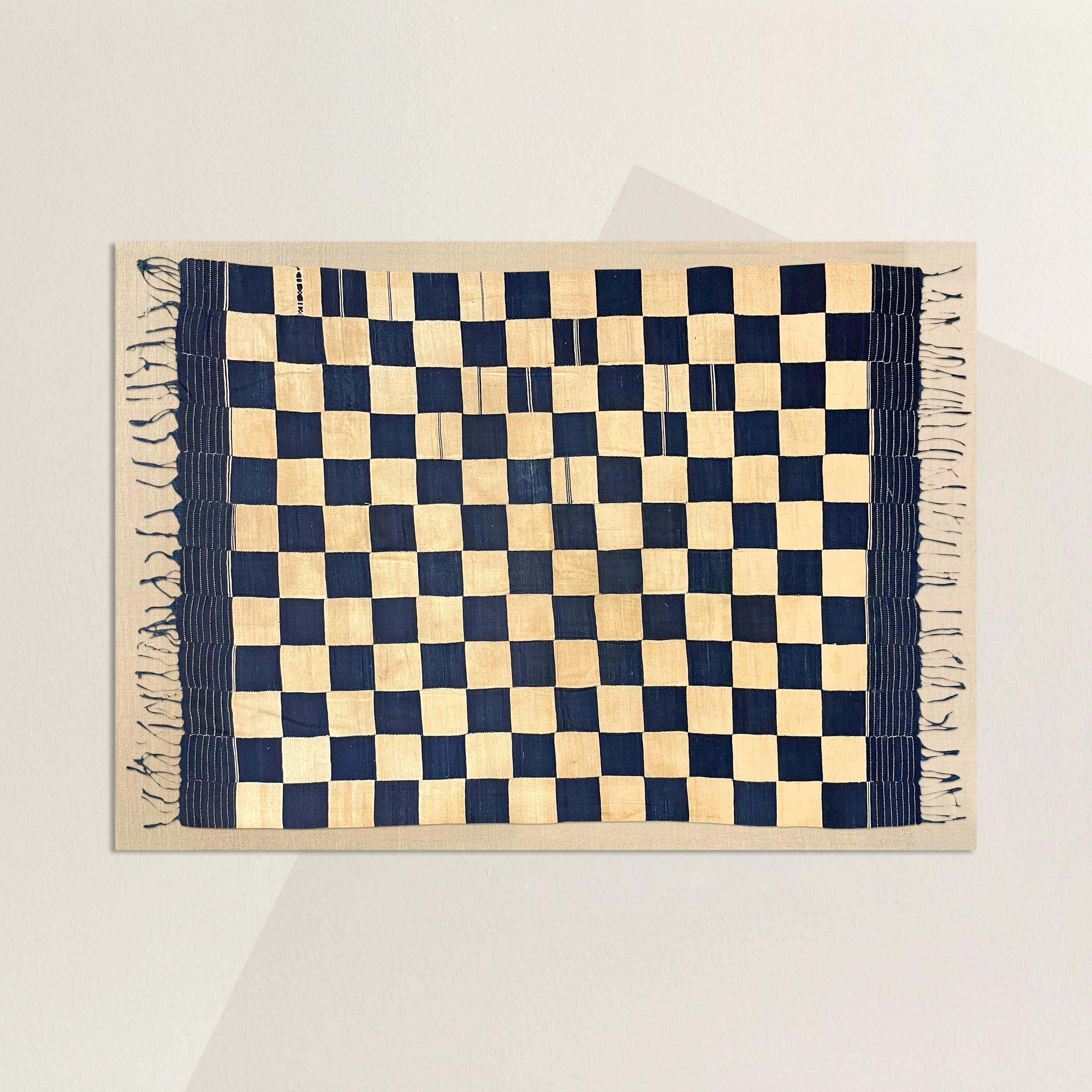 A wonderful early 20th century Mende handwoven Country Cloth composed of twelve narrow strips of indigo and cream dyed cotton and arranged to create a checkerboard pattern, and hand sewn together from selvedge to selvedge. In Sierra Leone, country