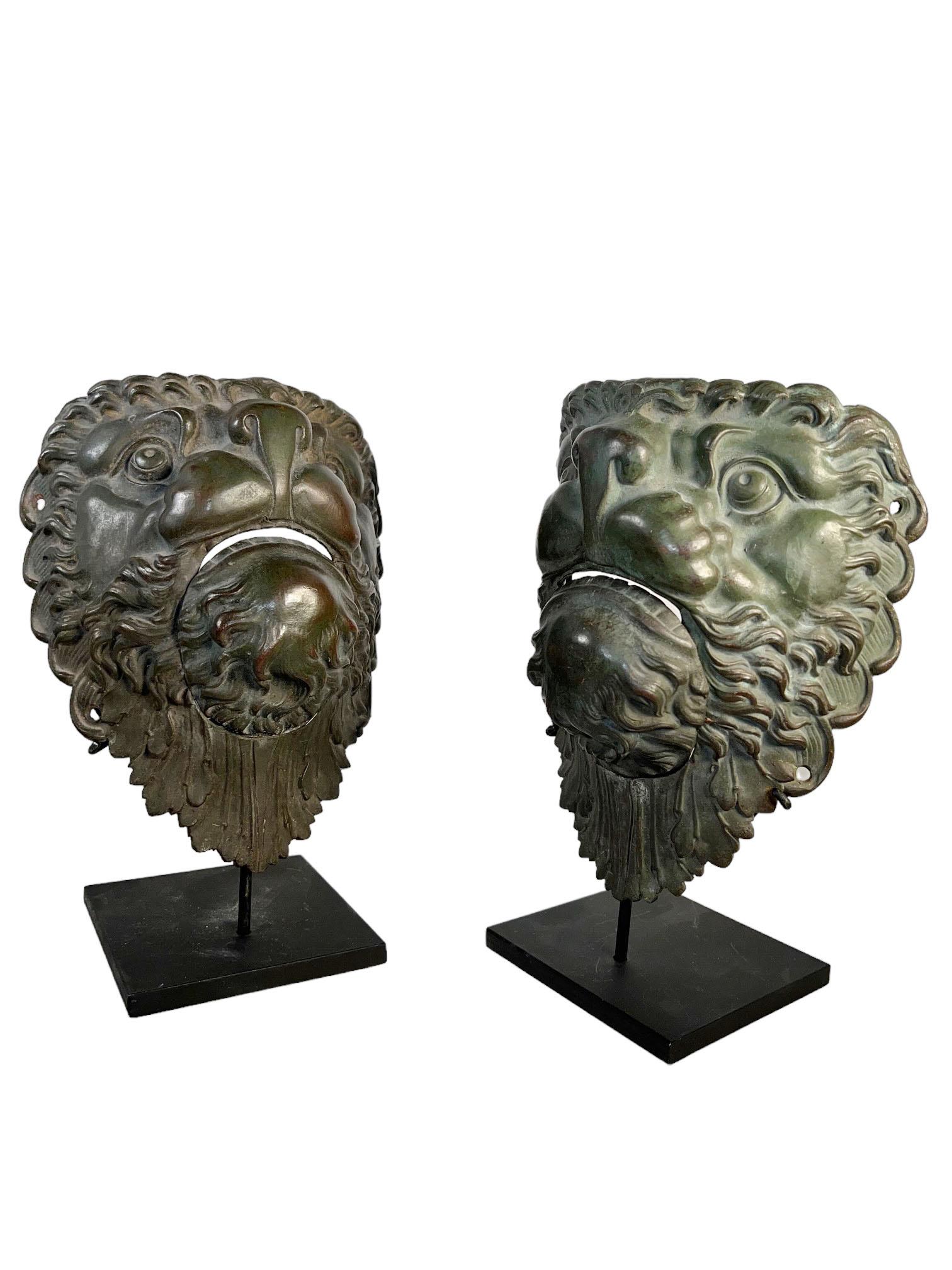 Una coppia di tasche da biliardo in bronzo a forma di maschera di leone montate su basi in metallo nero. Francia, circa 1890.