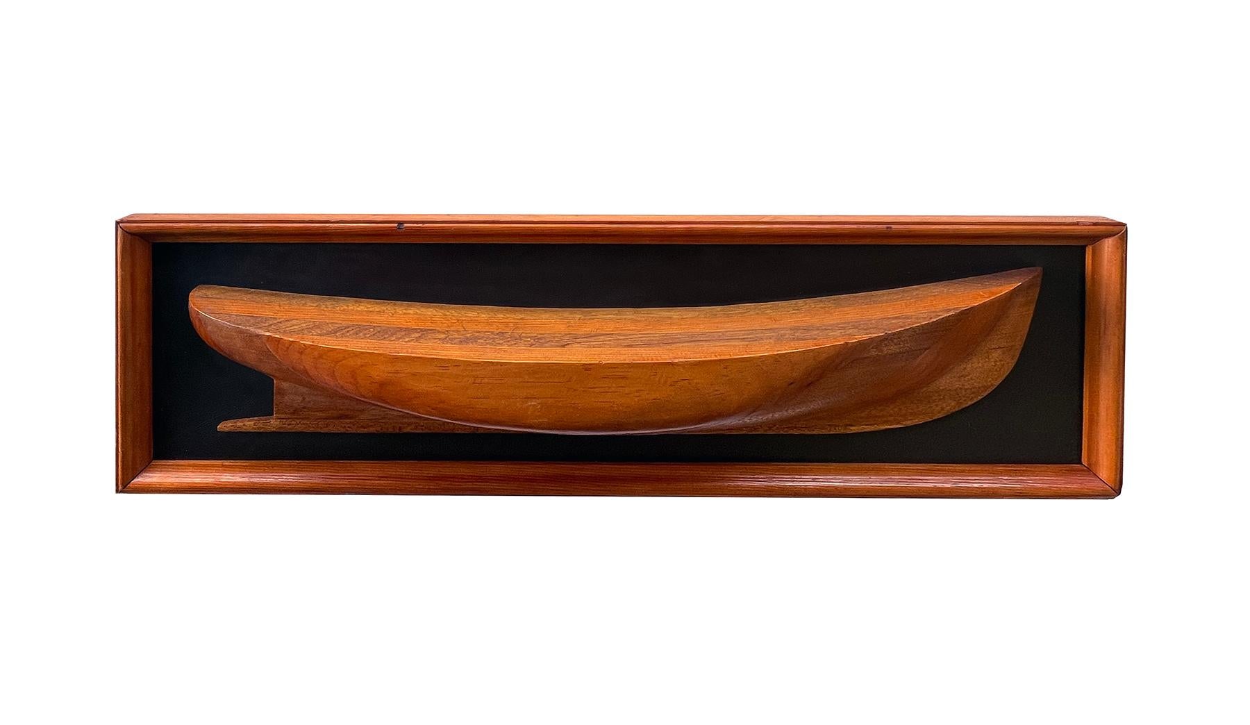 a handsome hand-crafted vintage American half-hull wooden boat builder's model constructed of laminated mahogany and maple in a warm honey-toned patina; within the original wooden frame with later black leather backing; the half-hull models
