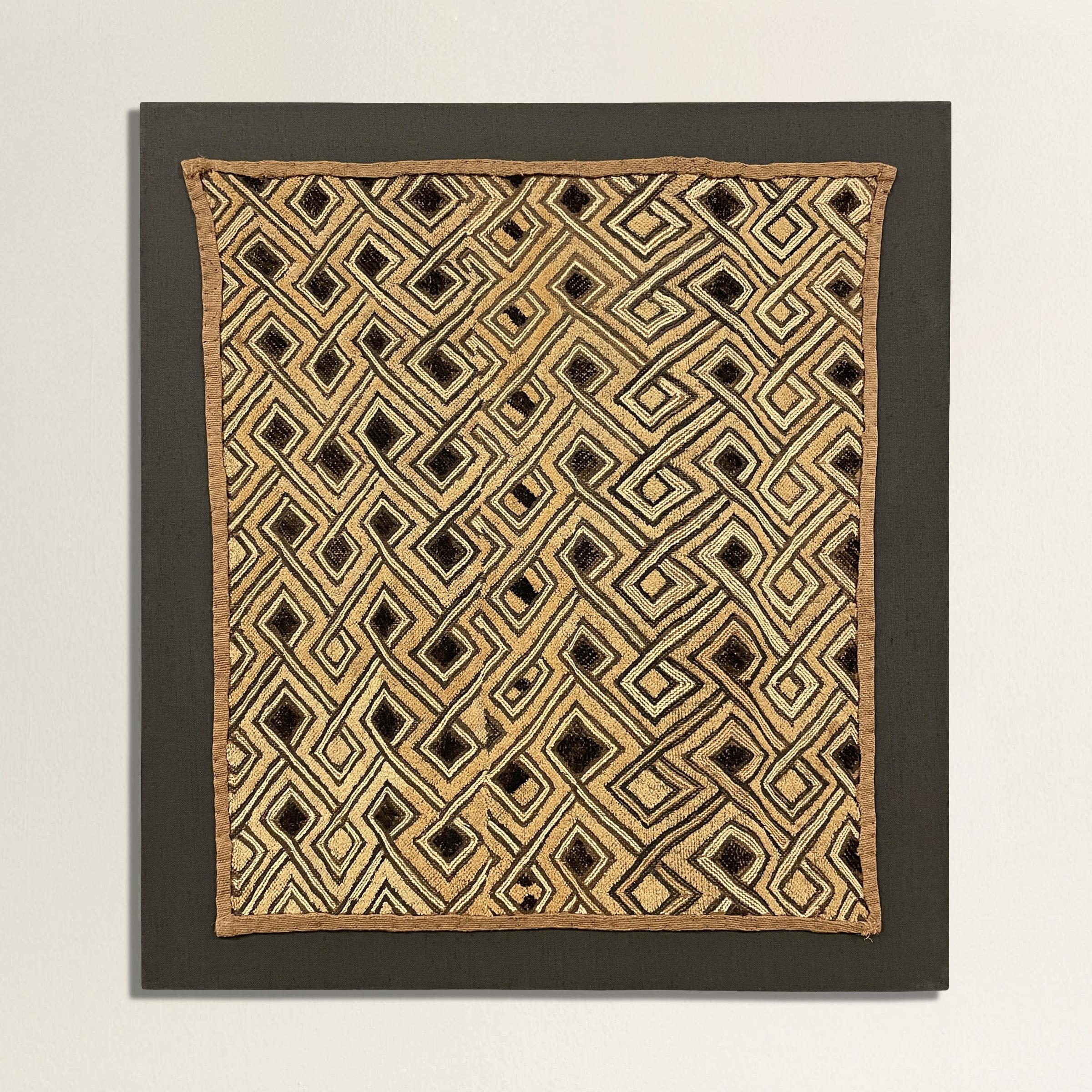 A striking 20th century Kuba cloth panel with a fantastic all-over interlocking meandering hook pattern woven in black and natural flat-weave and cut pile raffia. Kuba cloths are constructed of fine strips of raffia, knotted and cut, creating