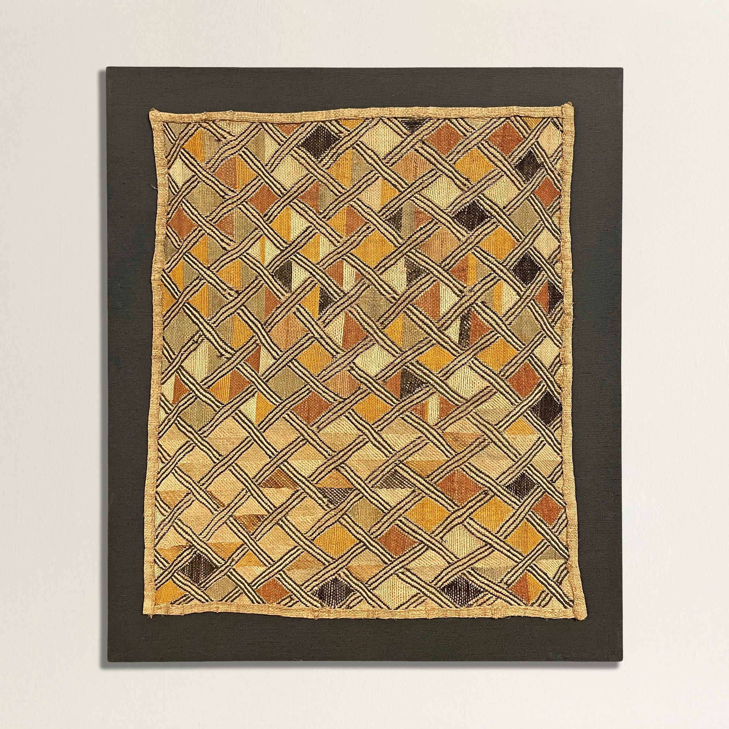 A wonderful mid-20th century Kuba Shoowa flat-weave multi-colored embroidered raffia cloth panel with a fantastic all-over geometric motif. Sometimes multiple panels are stitched together to create long dance skirts worn by men during various