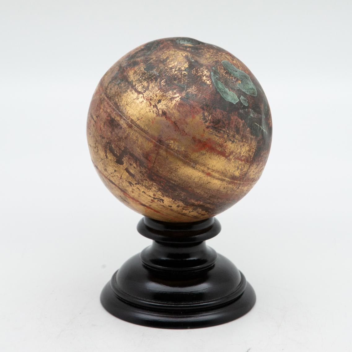 Mounted planet. Gilded copper sphere finial mounted on turned-wood ebony base. Measure: 9.5