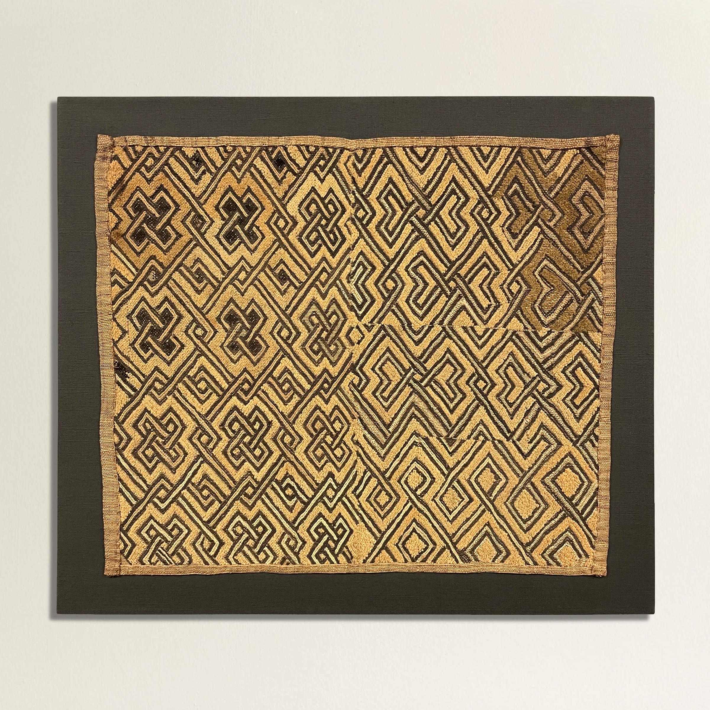A striking 20th century Shoowa Kuba cloth panel with a fantastic all-over interlocking meandering hook and knot pattern woven in black and natural flat-weave and cut pile raffia. Kuba cloths are constructed of fine strips of raffia, knotted and cut,