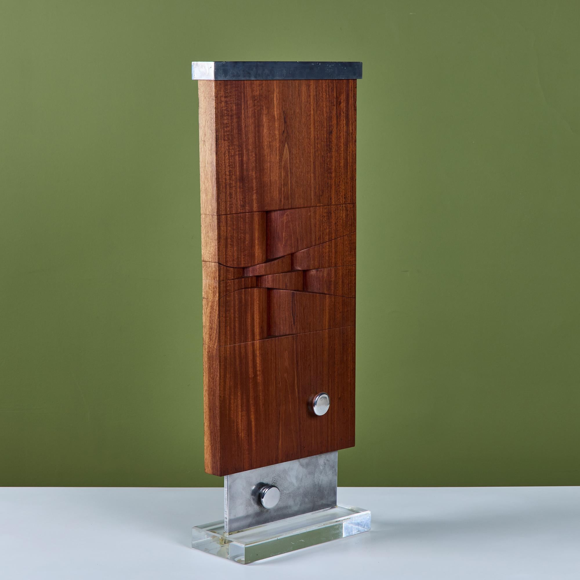 Mounted walnut and aluminum sculpture. The rectangular hand-carved wood sculpture with an aluminum cap and thin edge aluminum base is mounted to a clear resin base to give a floating effect. The piece also showcases two button accent