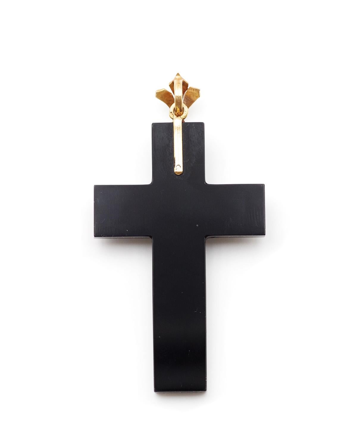 Mourning onyx cross pendant in 18 karat gold. 19th-century cross-shaped pendant, decorated with gold motifs set with fine half-pearls and centered with a pearl set by eight prongs. The bail is patterned with leaves adorned with half-pearls. Antique