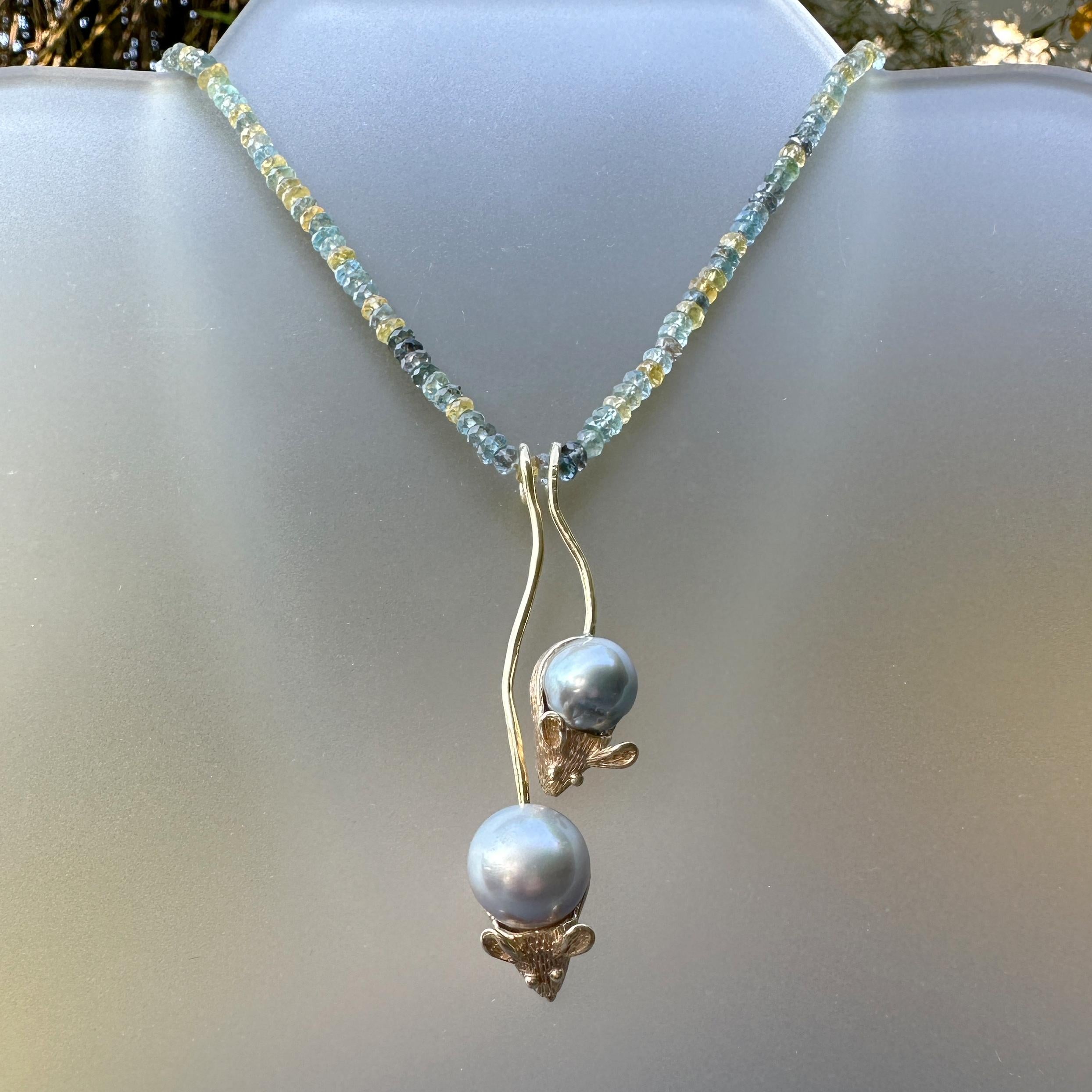 Two fat little mice in 14 karat yellow gold with silver-blue Tahitian pearl bodies hang happily by their tails from a string of sparkling aquamarine beads.

These mice are based on an antique silver charm that  we've had in the store for a while. 