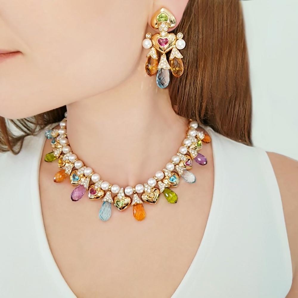 Moussaieff pearl, diamond and gemstone necklace and earring set made in 18k yellow gold.
The necklace is set all around the neck with thirty-four white 8mm pearls alternating with yellow gold links. Front of the necklace adorned with alternating 9