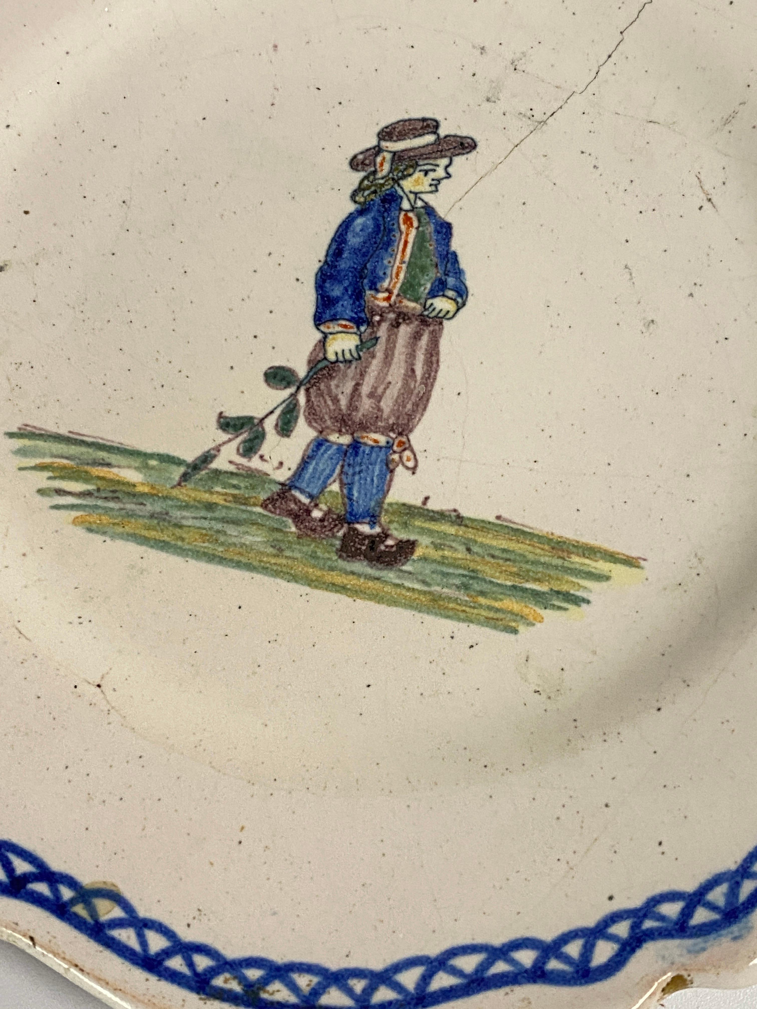 It is an Faience plate, made in the 19th century by Moustier, the colors are white blue green. It is signed on the back, with an X representing the monogram of Moustier.