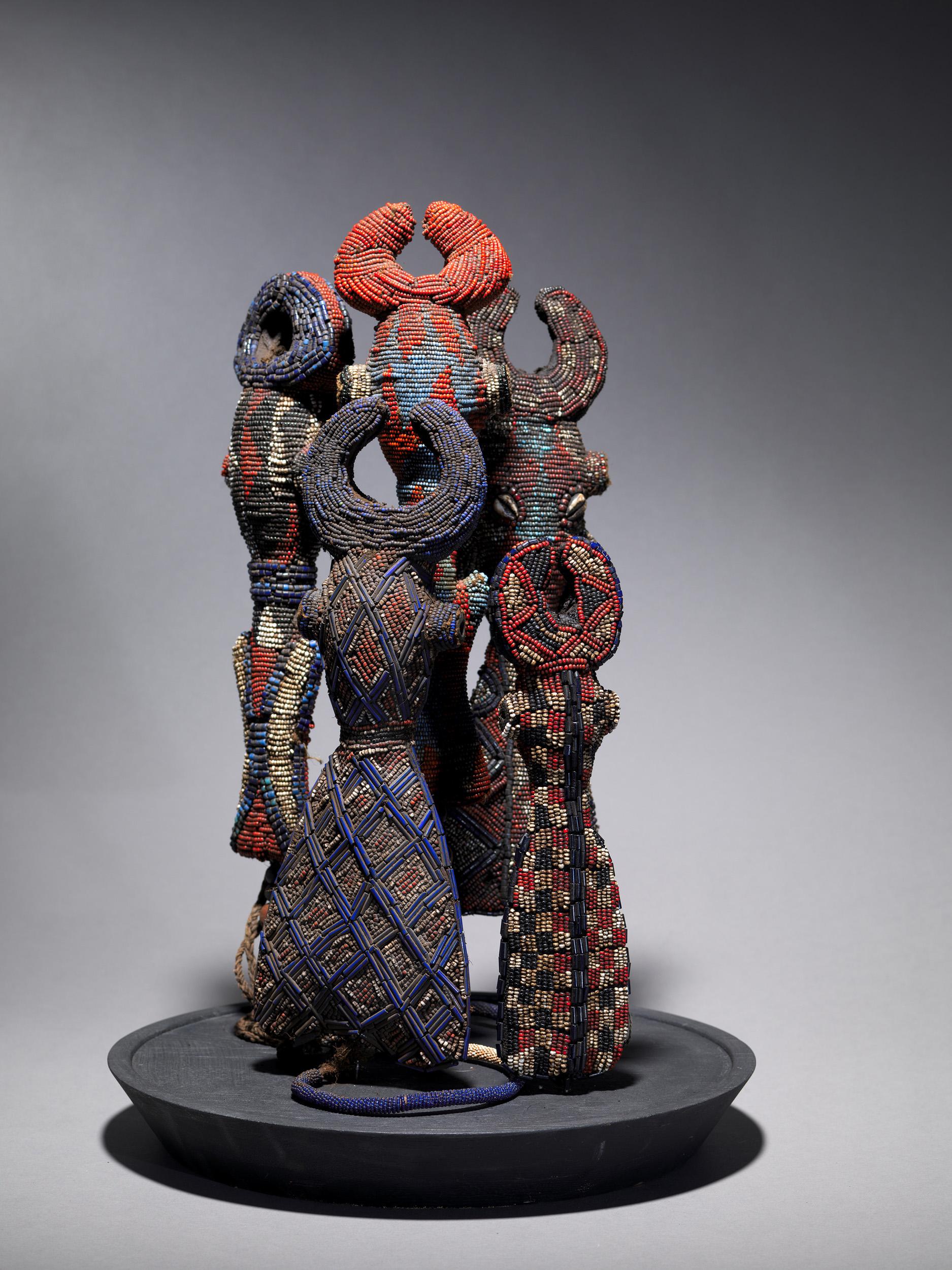 Five ceremonial beaded flutes or whistles from the Cameroon grasslands. They come in various geometric forms, taking on the shape of a hollowed, stylized figure that combines human and animal features. Most have a hole or some device to attach a