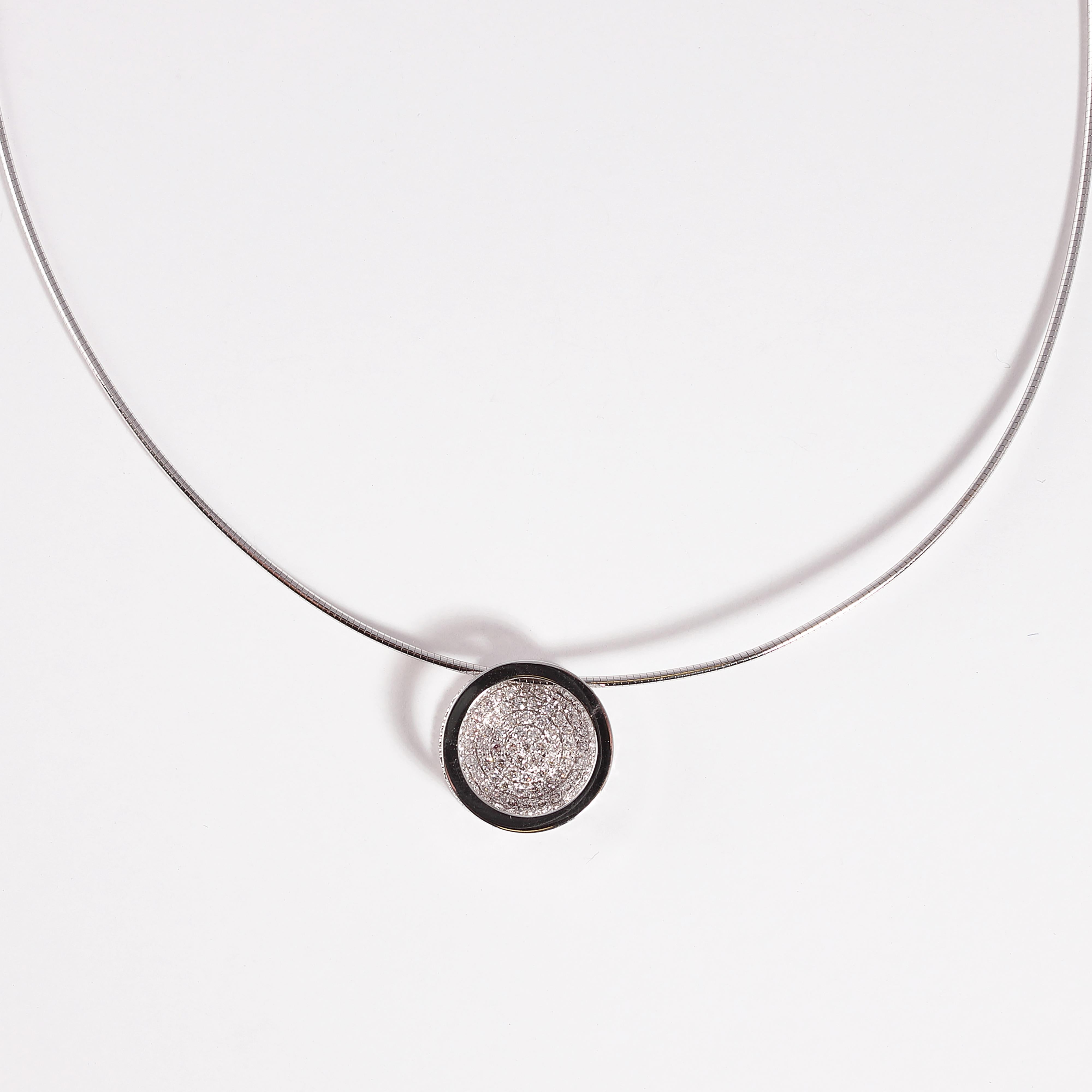This 18 karat, white gold, circular pendant is suspended from an 18 karat white gold, snake chain, measuring 16 inches in length.  The pendant supports pave set diamonds with a total stated weight of 0.60 carats. 