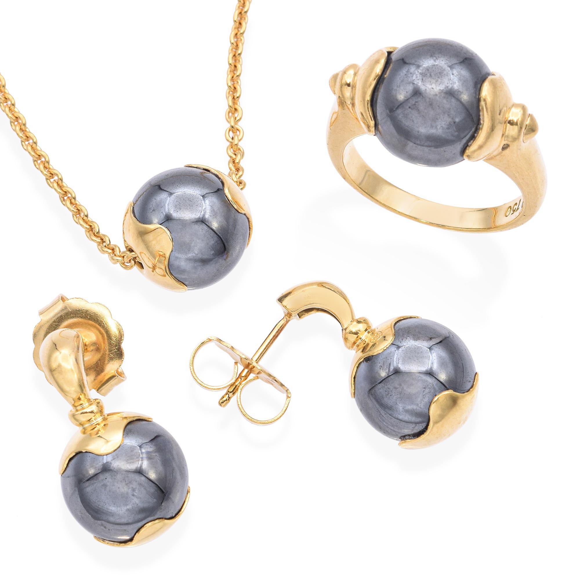 Cette étonnante parure de bijoux en or jaune 18 carats à l'hématite respire l'élégance audacieuse et le contraste raffiné. Composé de pierres d'hématite lisses et miroitantes serties dans un riche or jaune 18 carats, l'ensemble comprend un collier,