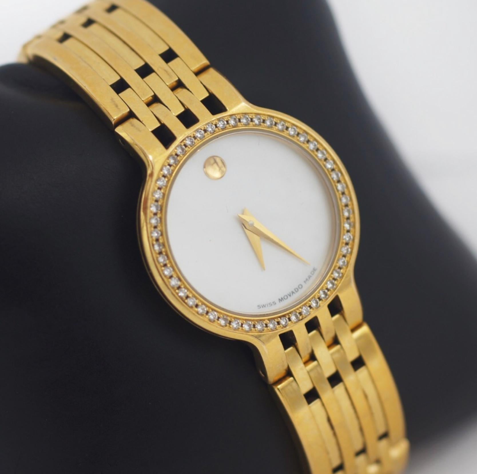 This beautiful Movado wristwatch from the Esperanza collection is beautifully constructed of gold tone stailess steel and has a diamond-set bezel that bringings out the Mother of pearl dial and features Movado's signature dot at 12