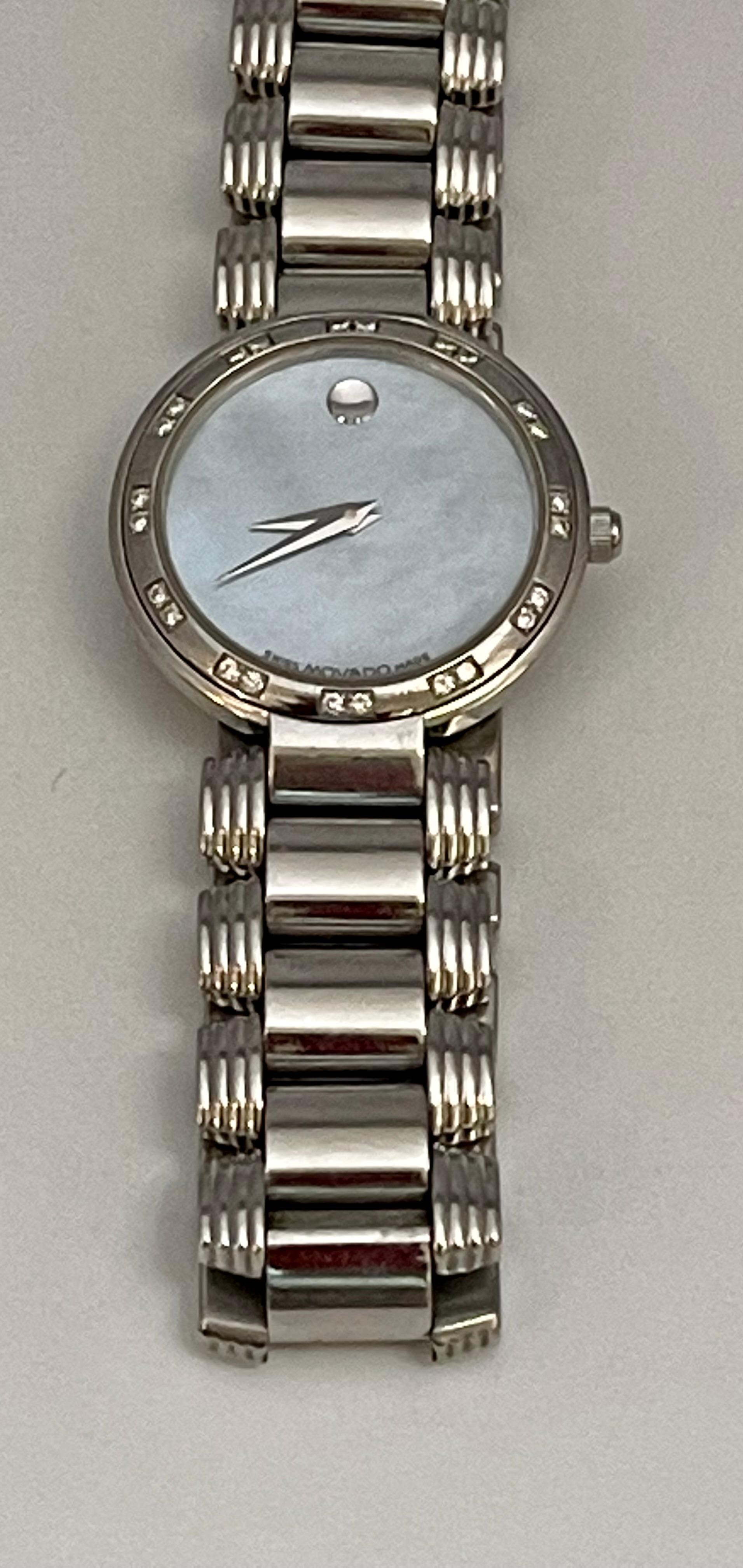 Pre owned
Mother of Pearl Dial and has diamonds on it 
Brand:	Movado	Watch 
Shape:	Round
Case Size:	26 mm	
Water Resistance:	30 m (3 ATM)	
Country/Region of Manufacture:	Switzerland
	Case Material:	Stainless Steel
Style:	Luxury: Sport Styles,