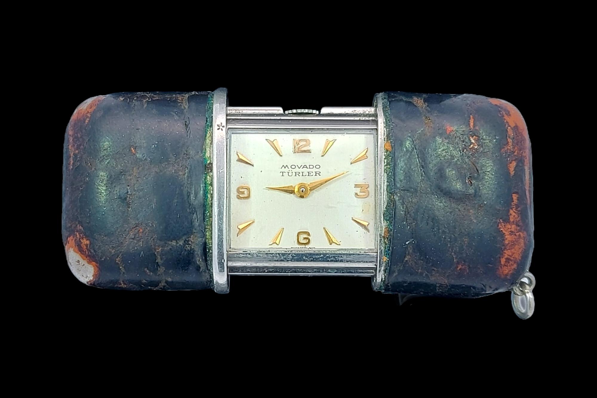 Turler Movado, Slide Travel Watch-Clock, Handtaschenuhr, mit Ständer.

Dieses Exemplar ist kleiner als üblich und extrem selten und sammelwürdig.

Abmessungen: 40,5 mm geschlossen, 61 mm offen x 26,3 mm x 12,9 mm 

Gesamtgewicht: 40,7 Gramm / 1.440