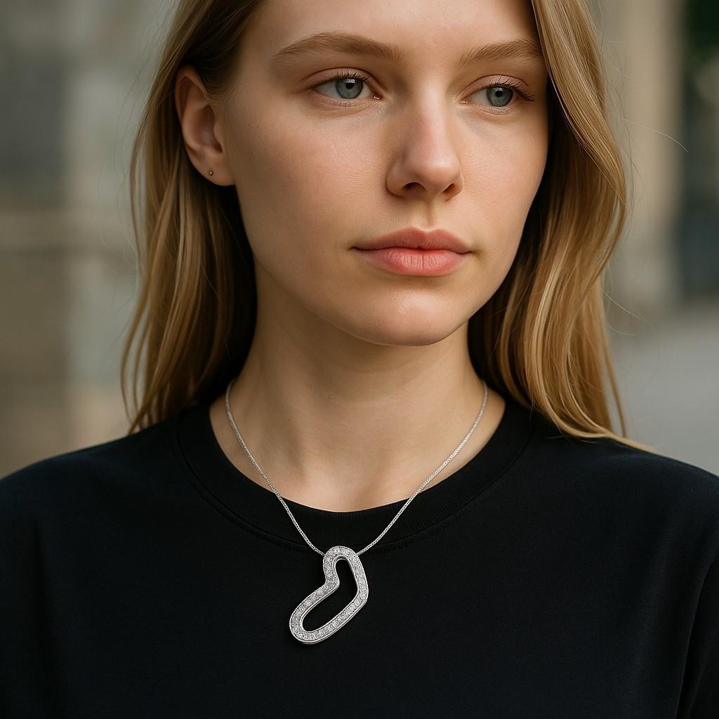 Das Movado Heart Diamond, mit einem Gewicht von ca. 0,45 Karat, Eighteen Karat White Gold Necklace Pendant ist ein Schmuckstück, das einen herzförmigen Anhänger aus 18 Karat Weißgold und mit Diamanten besetzt aufweist. Die Marke Movado ist bekannt