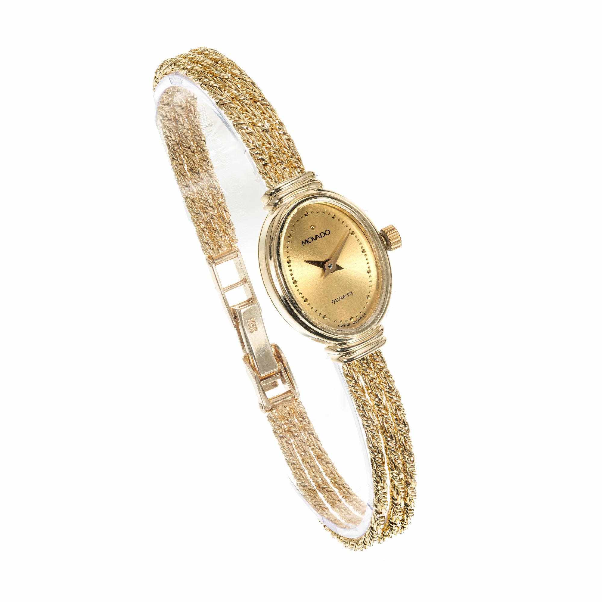Ladies oval Movado solid 14k gold wristwatch with gold three strand Movado bracelet. Quartz movement 

Length: 22.70nn
Width: 15.10mm
Band width at case: 5.32mm
Case thickness: 5.16mm
Band: Three strand gold chain stamped: M 14k
Crystal: