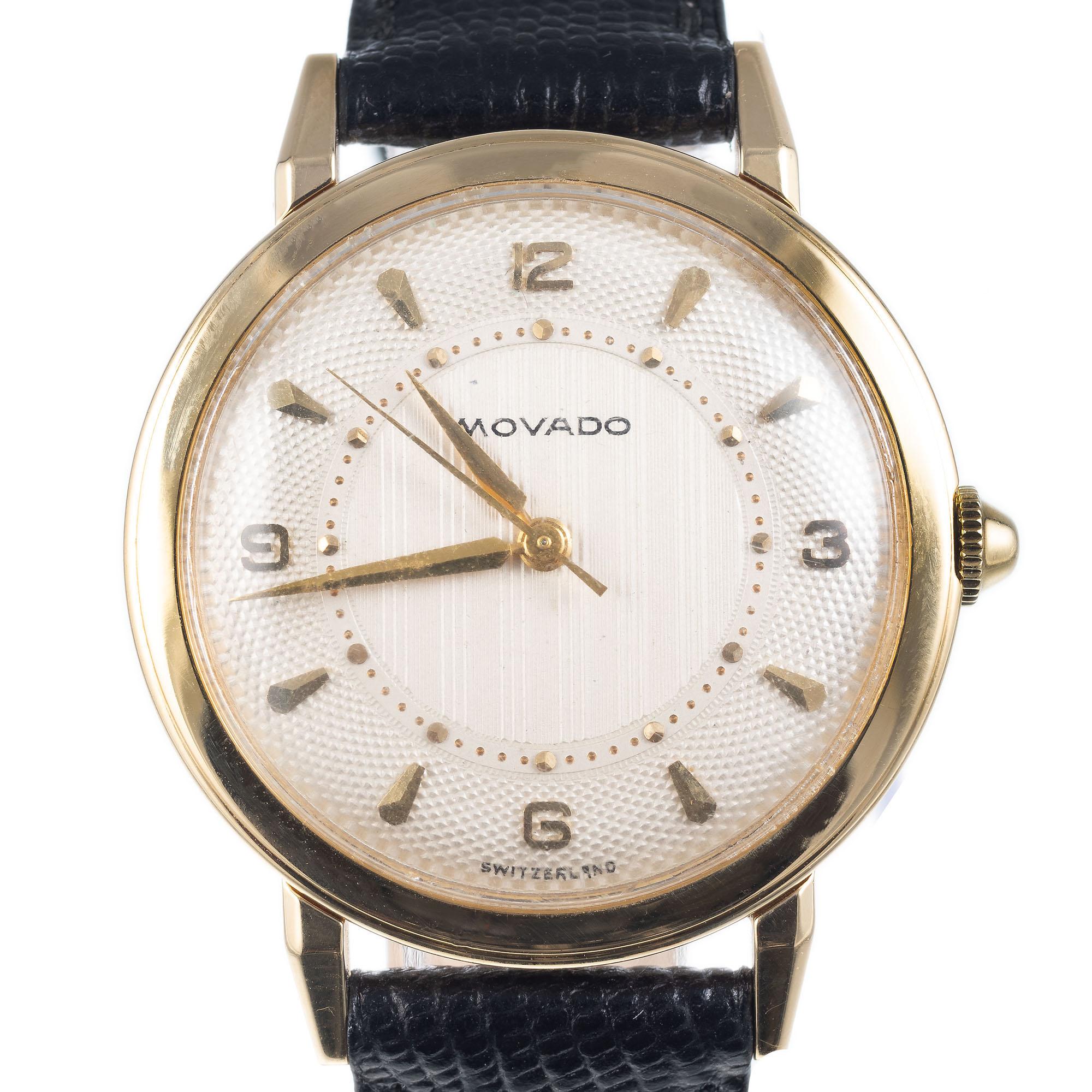 Movado 18k yellow gold strap wristwatch with cream colored factory original textured dial. New black leather strap.  Circa 1960.

Length: 41.06mm
Width: 33nn
Band width at case: 16mm
Case thickness: 9.32mm
Band: Black genuine leather New
Crystal: