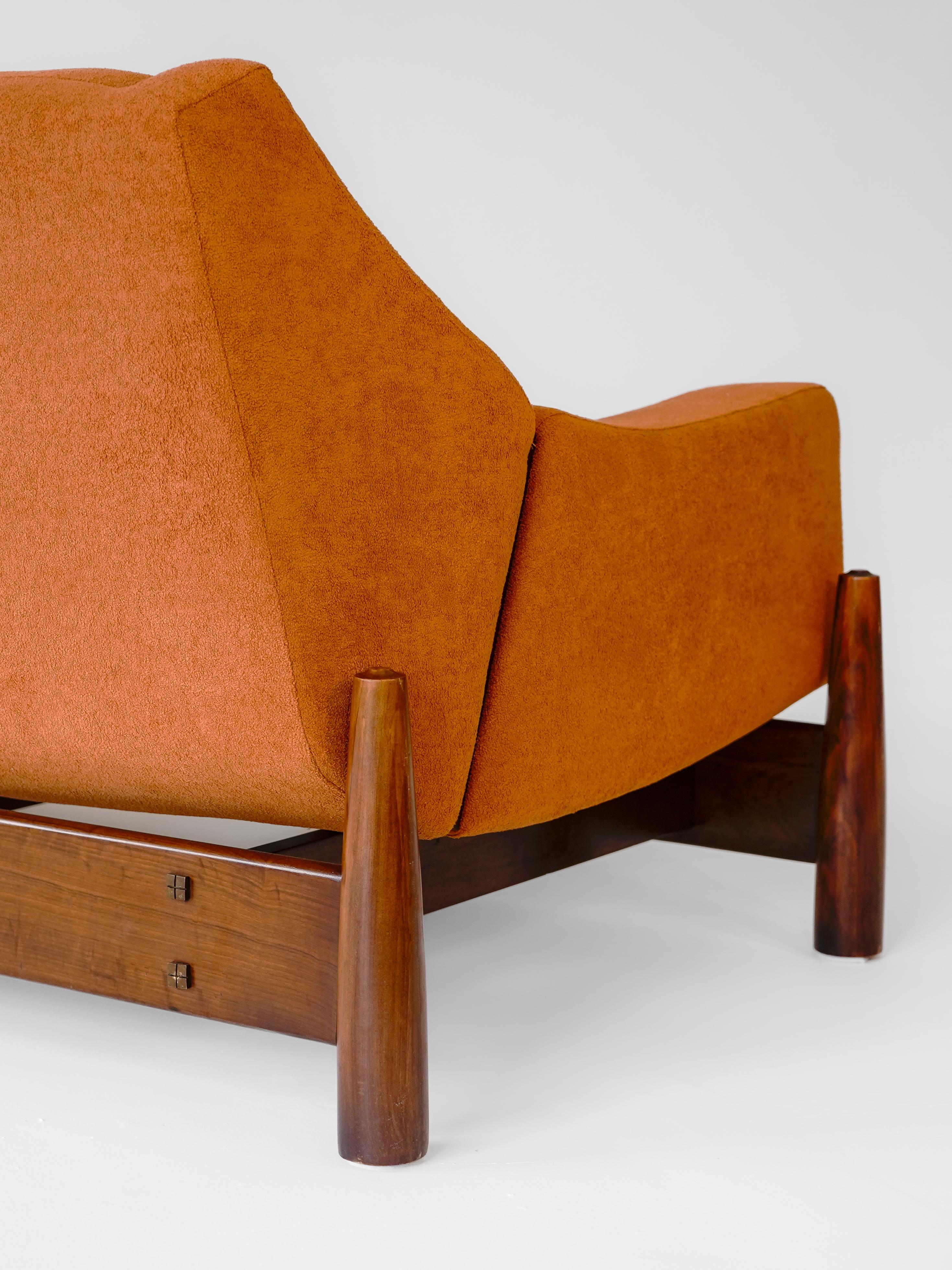 Bellamente fabricado por Móveis Cimo en Brasil durante la década de 1960, este elegante sofá ejemplifica el atractivo atemporal del diseño moderno brasileño. La pieza presenta un marco de madera maciza con líneas limpias y esculturales, sello
