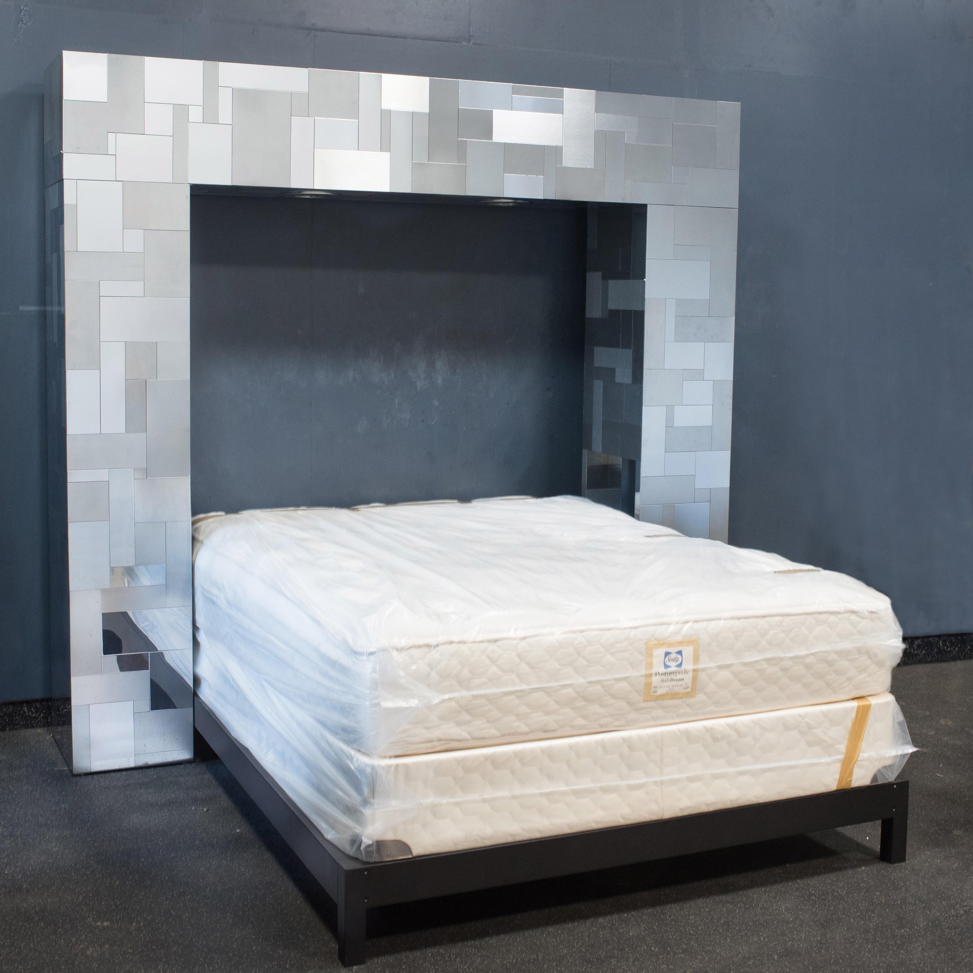 Phenomenal iconic design by Paul Evans is exemplified in this brushed and shiny chrome patchwork cityscape queen sized headboard. On the inside periphery of the headboard there are two cubby shelves and a thoughtful opening for an electrical cord.