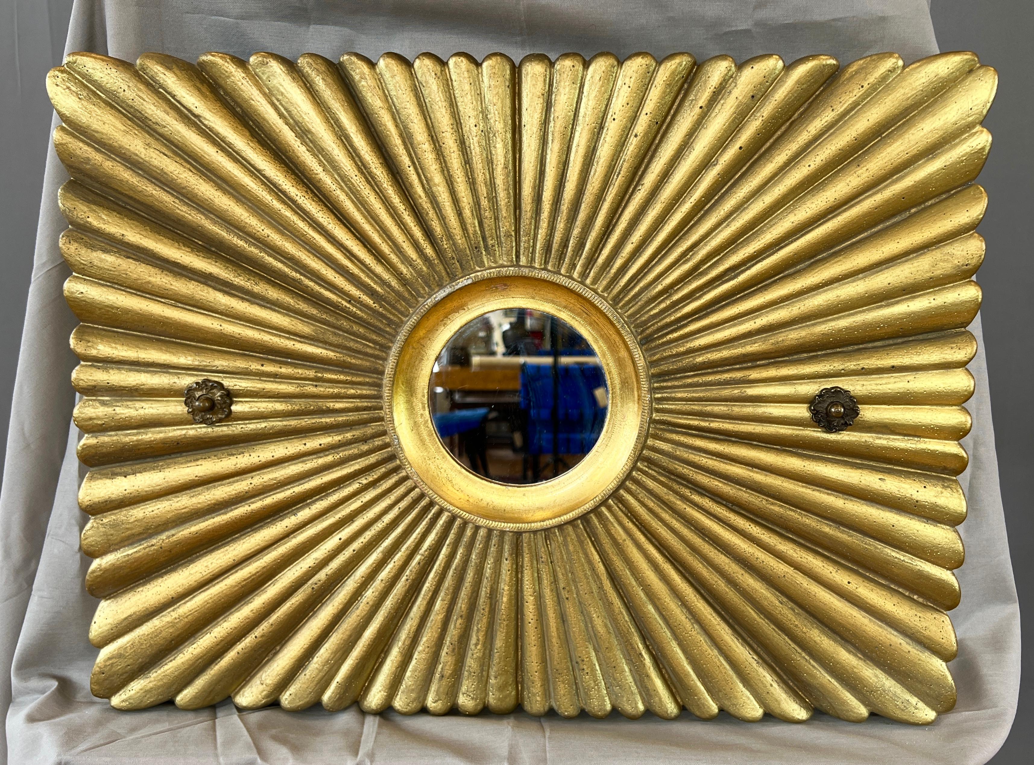 A circa 1920 Art Deco gold painted solid plaster sunburst decoration with gilt metal-framed mirror from an upscale movie theater or playhouse.

A classic décor element rendered in clean, timeless style, with a very dimensional rectangular sunburst