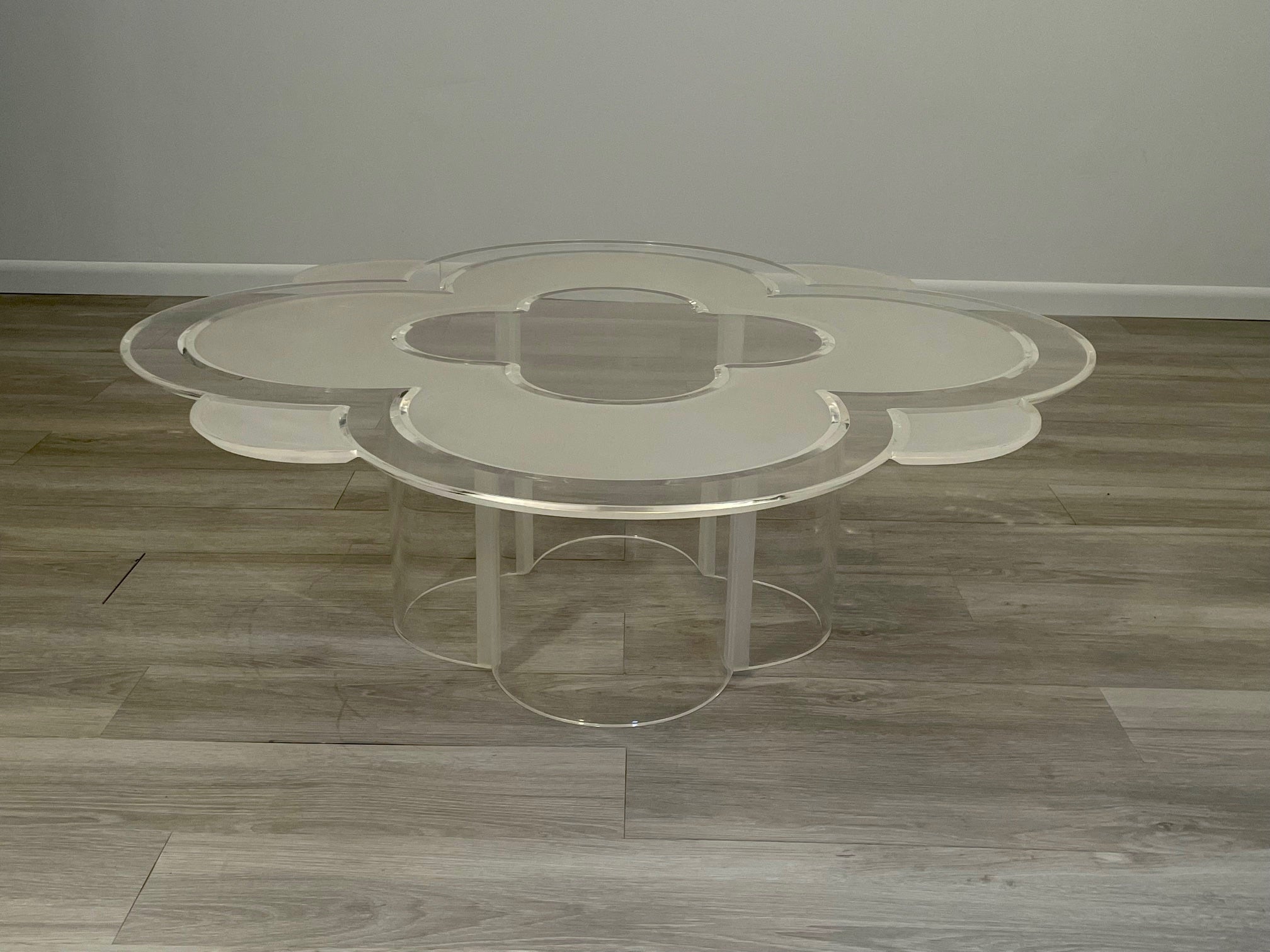 We've never seen another one like this memorable camelia flower shaped lucite coffee table having a mix of frosted and clear lucite, scalloped edges and sculptural shaped base. Reminds us of the camelia flower often seen in Chanel necklaces. So