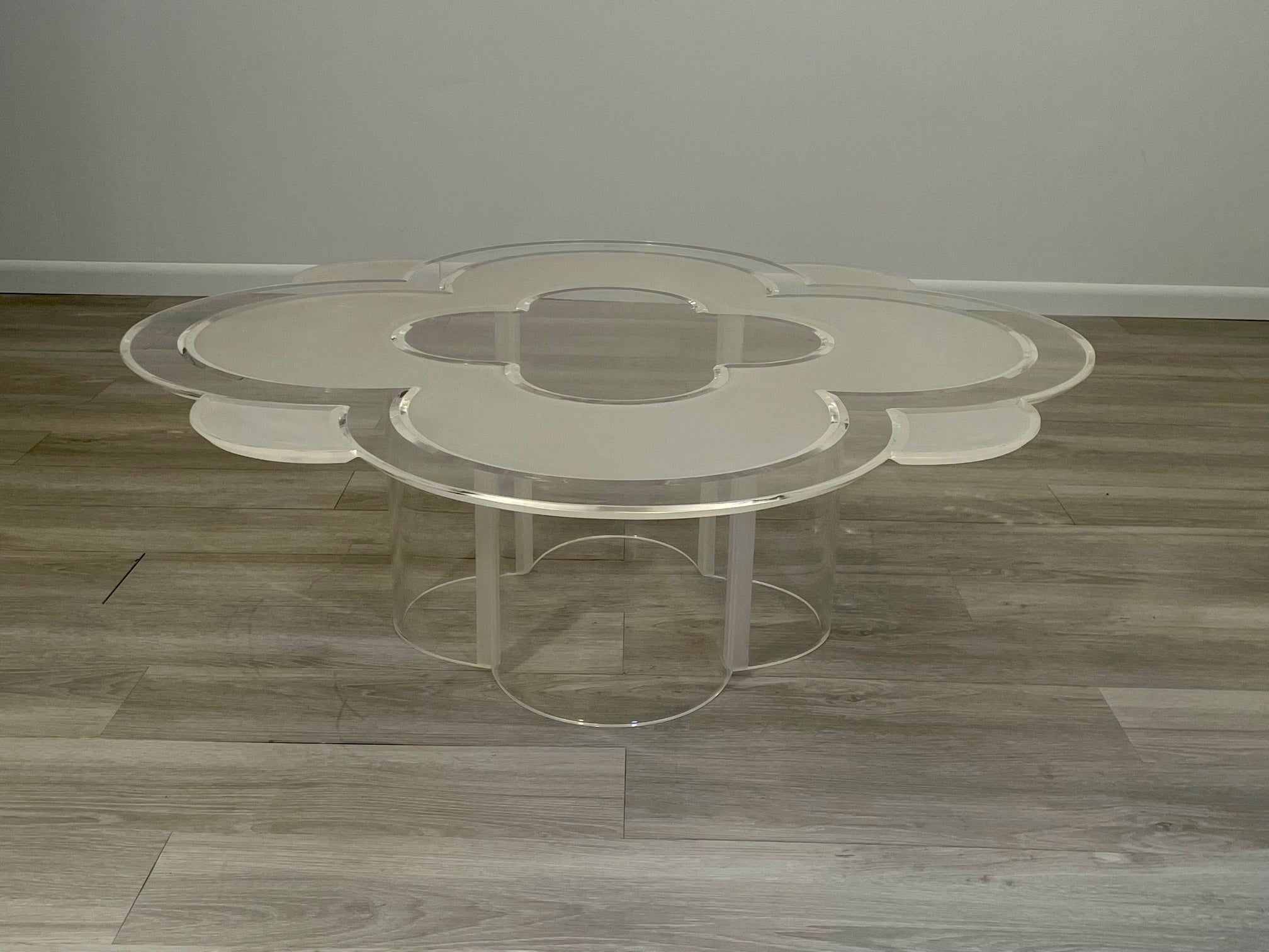 Nous n'en avons jamais vu d'autre comme cette mémorable table basse en lucite en forme de fleur Camelia qui présente un mélange de lucite givrée et transparente, des bords festonnés et une base sculpturale. Elle nous rappelle la fleur de camélia que