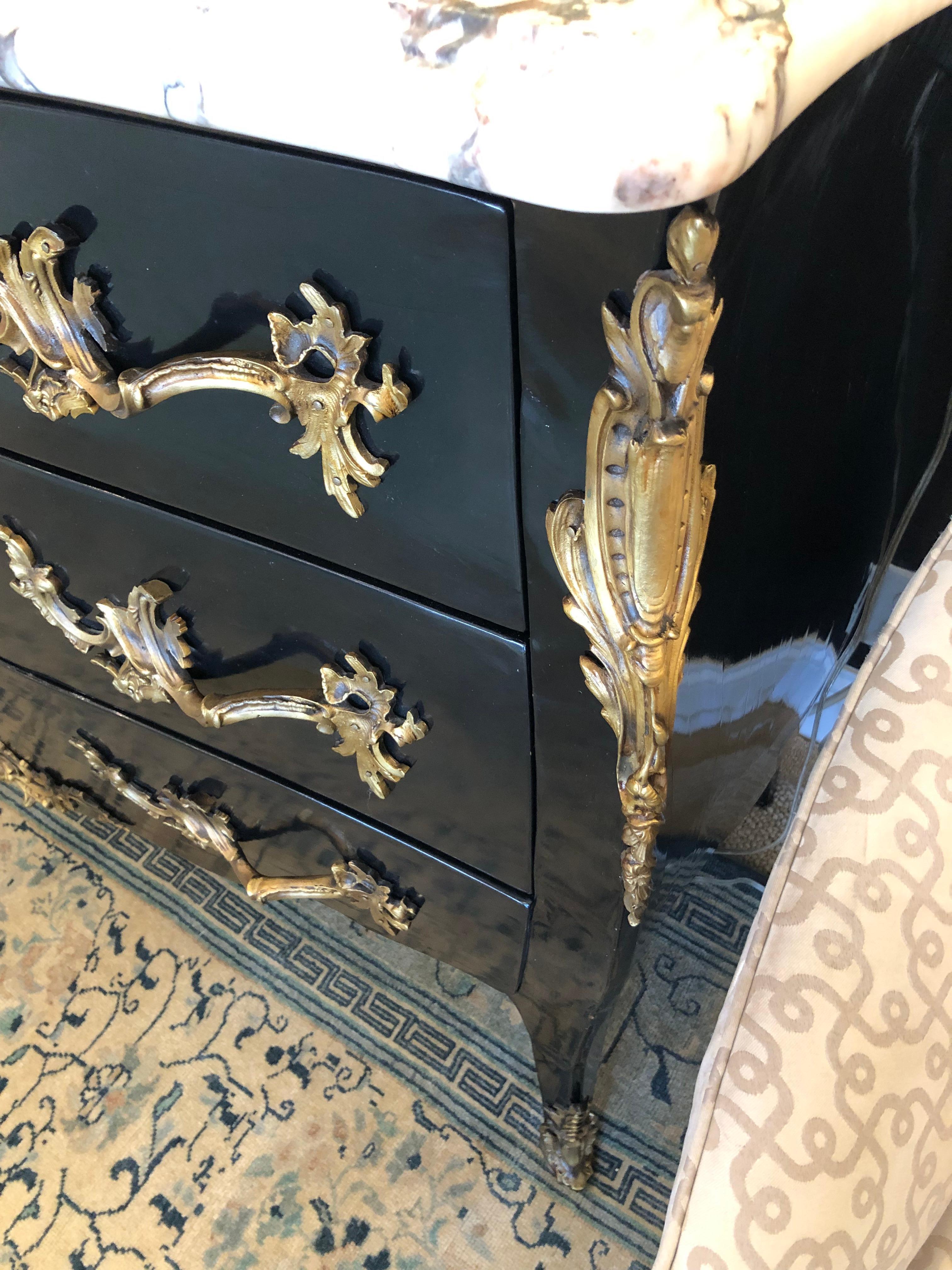 Show stopper super glamorous chest of drawers having black body, chunky brass hardware and decoration including feet, and sensationally yummy cream, black and pink lively marble top.
