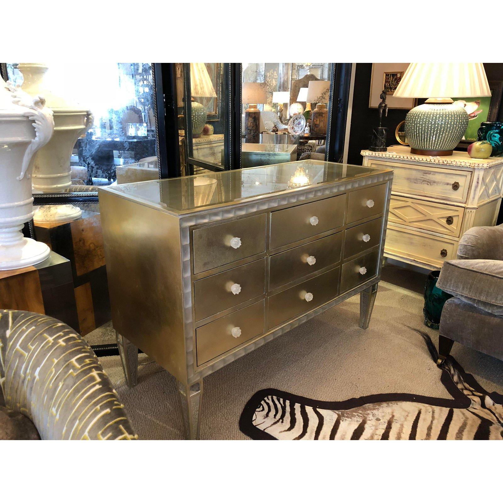 Glamorous custom made Hollywood Regency style chest in a gilt and silvered finish. Chest has a molded acrylic trim surround and molded flower drawer pulls that look like Lalique. Top is inset gilt colored beveled glass and each drawer is lined in