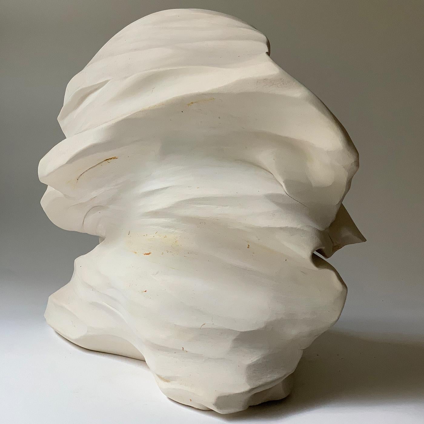A two-faced sculpture of prevailing convex profile, this extraordinary oeuvre draws inspiration by the movements of the earth, by the fluidity of lava. Painted in white to catch the light at its highest expression, it features a roughly textured