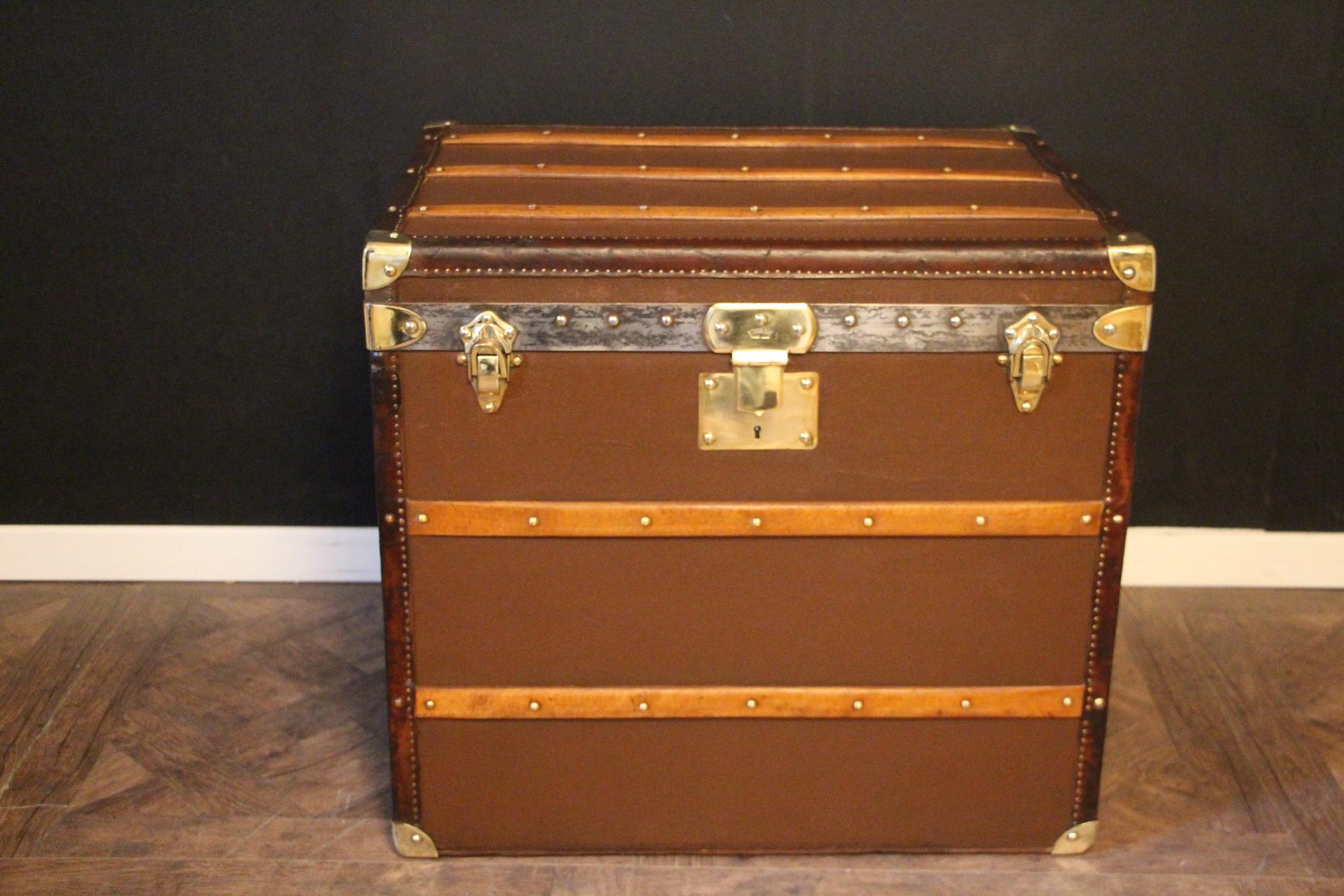 This Moynat hat trunk features chocolate brown canvas, lmatching color leather trim and solid brass corners, lock and latches. Its lock is stamped Moynat. as well as its 2 latches It has got large side handles in leather and its handle latches are