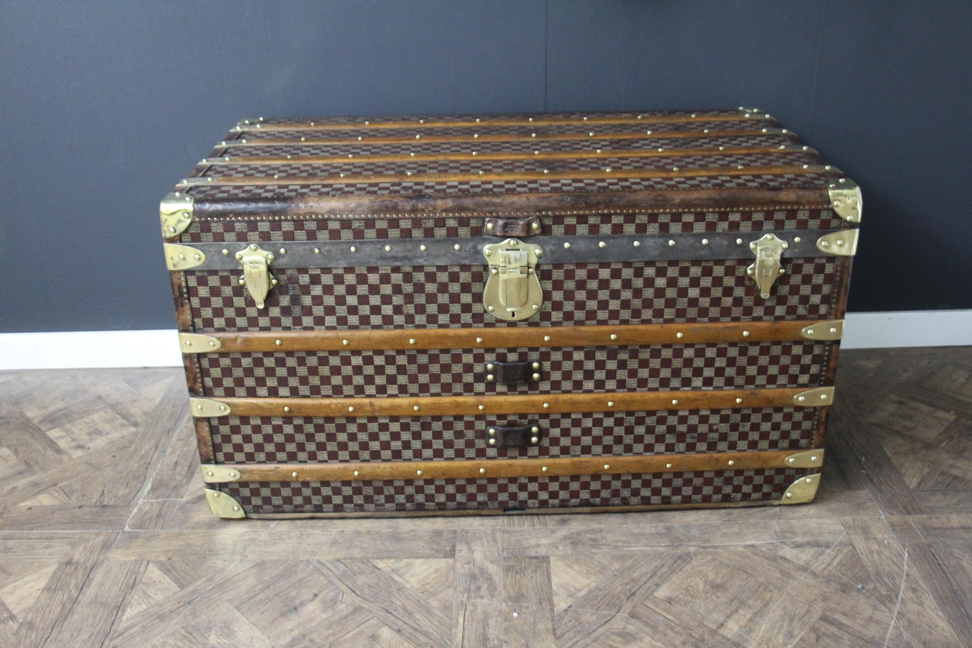 This beautiful and very rare Moynat trunk features beautiful checkers canvas, chocolate color leather trim, large leather side handles with stamped Moynat flanges and solid brass stamped Moynat lock and clasps. Its patina is magnificent. Moreover it