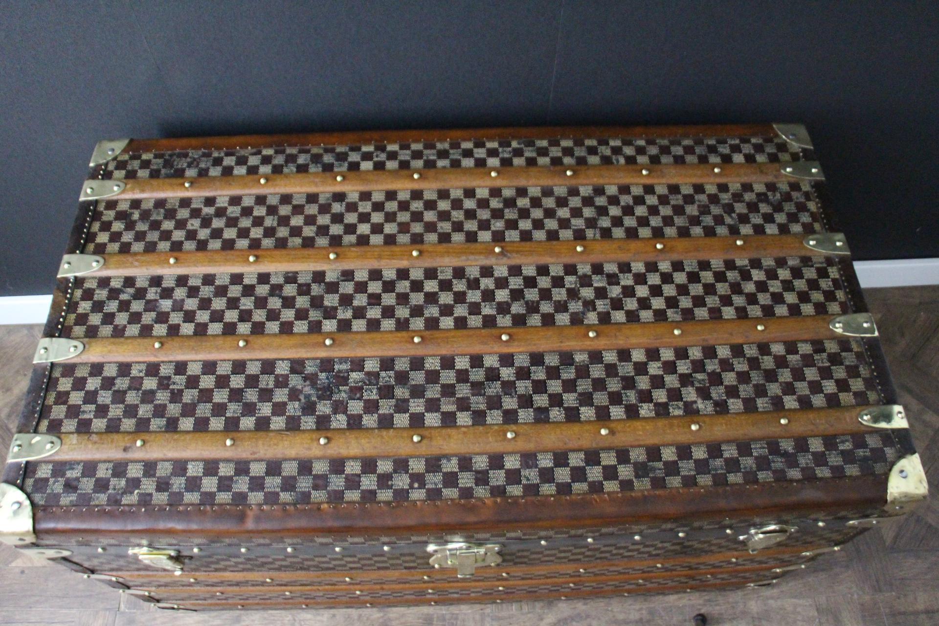 This beautiful and very rare Moynat trunk features beautiful checkers canvas, chocolate color leather trim, large leather side handles with stamped Moynat flanges and solid brass stamped Moynat lock and clasps. Its patina is magnificent. Moreover it