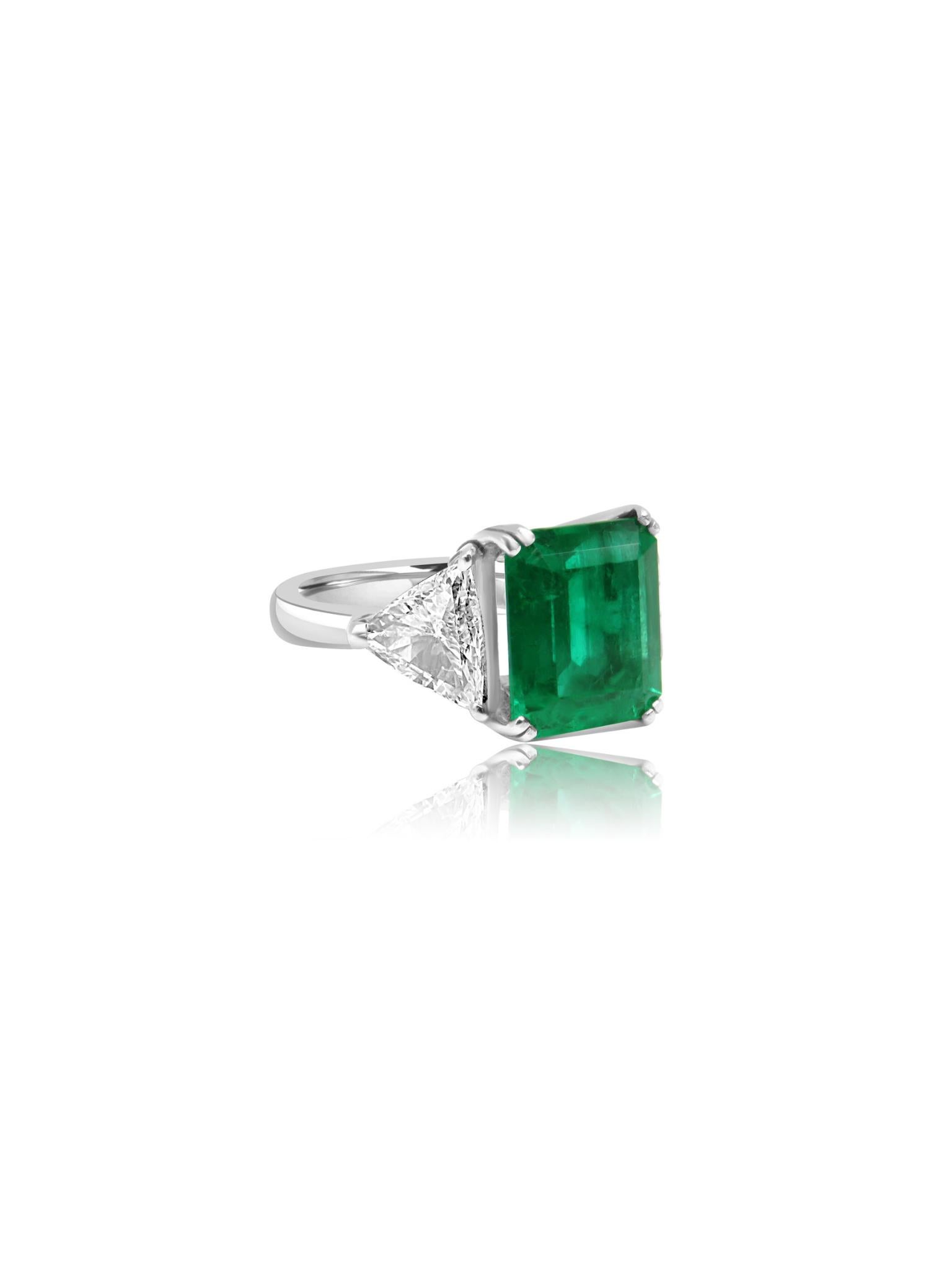 Este anillo de esmeralda colombiana es una auténtica obra maestra, engastada en oro blanco de 18 quilates. En el corazón del diseño se encuentra una esmeralda de talla radiante de 6,64 quilates, conocida por su intenso y exuberante tono verde, que