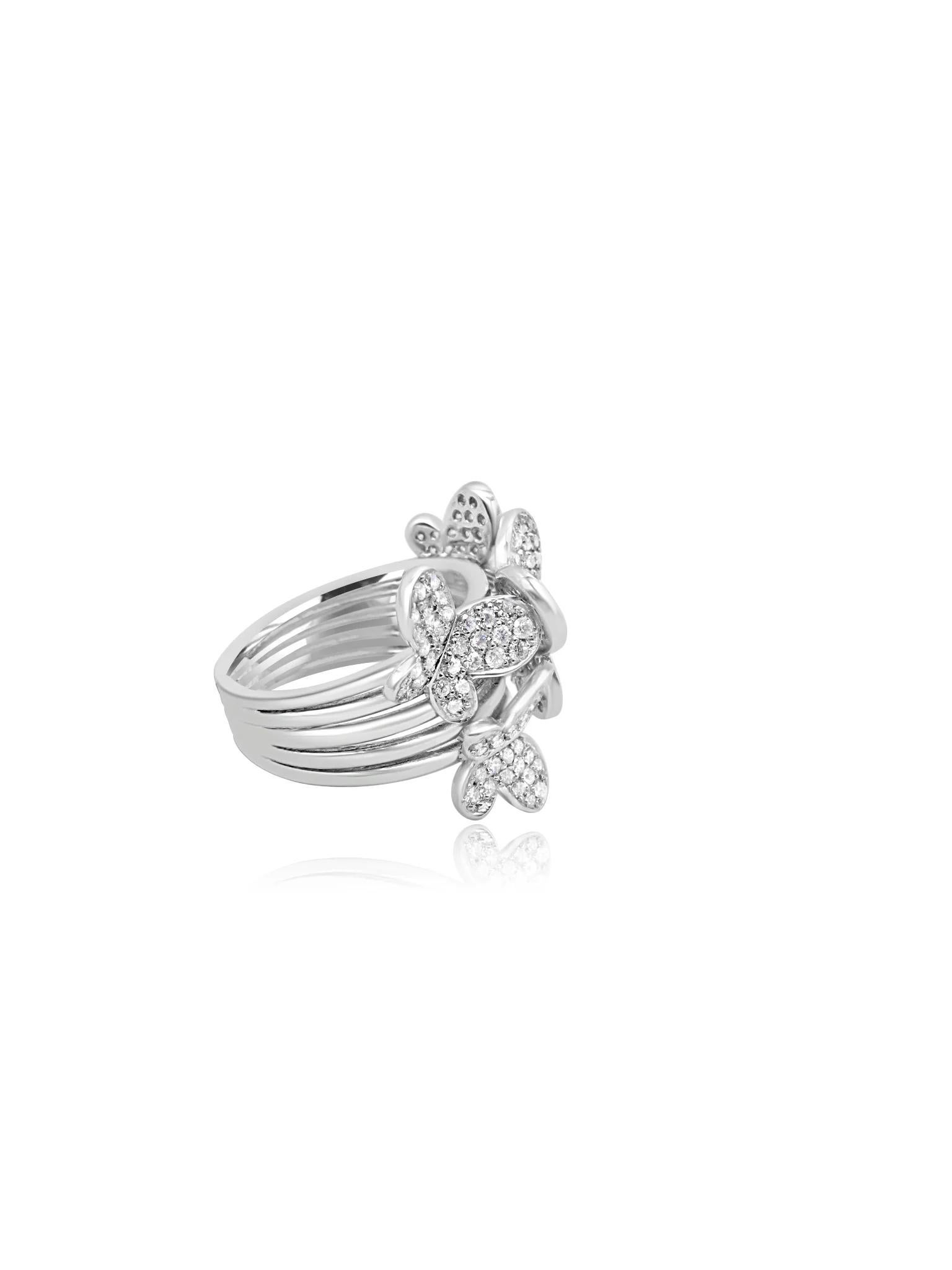Elaborado con maestría en oro blanco de 18 quilates, este elegante anillo luce exquisitos motivos de mariposas adornando la parte frontal y los laterales, cada uno de ellos incrustado con deslumbrantes diamantes. El intrincado diseño y los