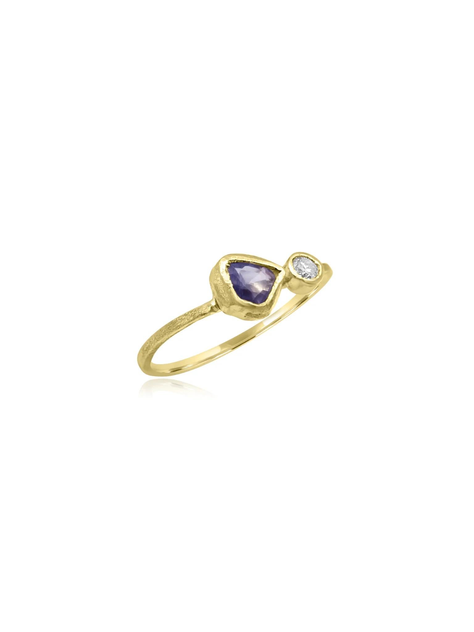 Bellissimo anello in oro 18 carati realizzato a mano in Cornovaglia. La sottile fascia presenta una texture unica, che aggiunge profondità e carattere al design. Al centro, una gemma di zaffiro a pera e un diamante a taglio rotondo splendidamente